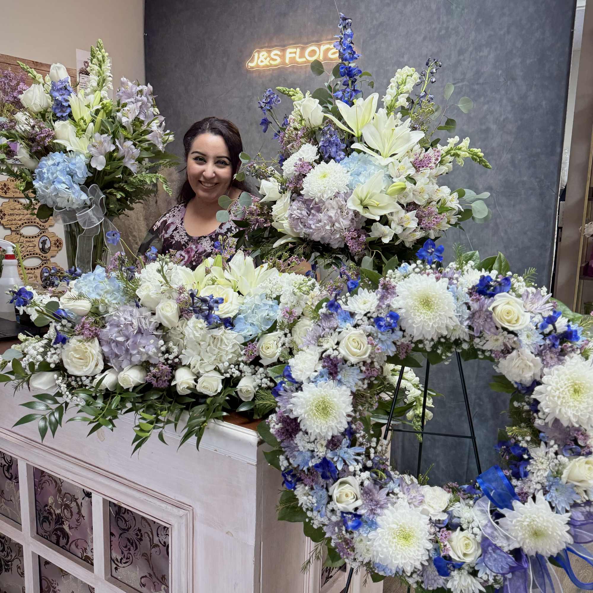 Large floral wreaths and arrangements in white, blue, and lavender