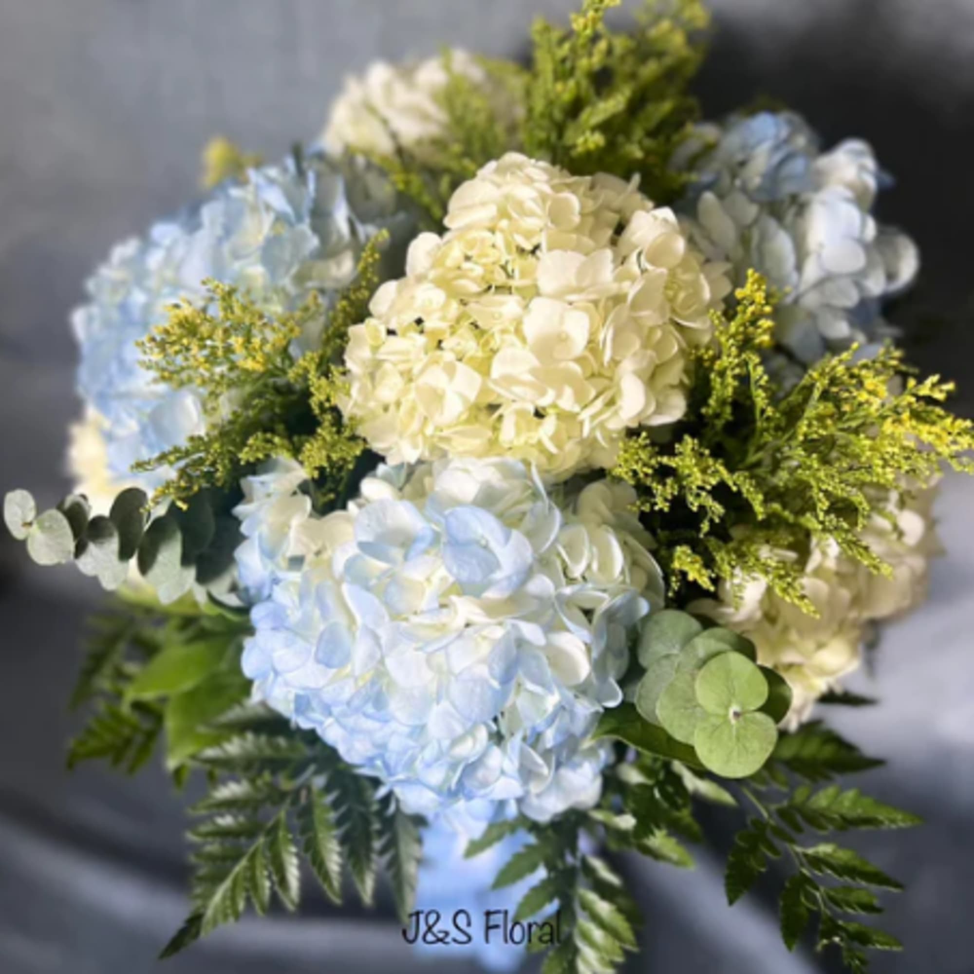 Bouquet of blue and white hydrangeas with green filler