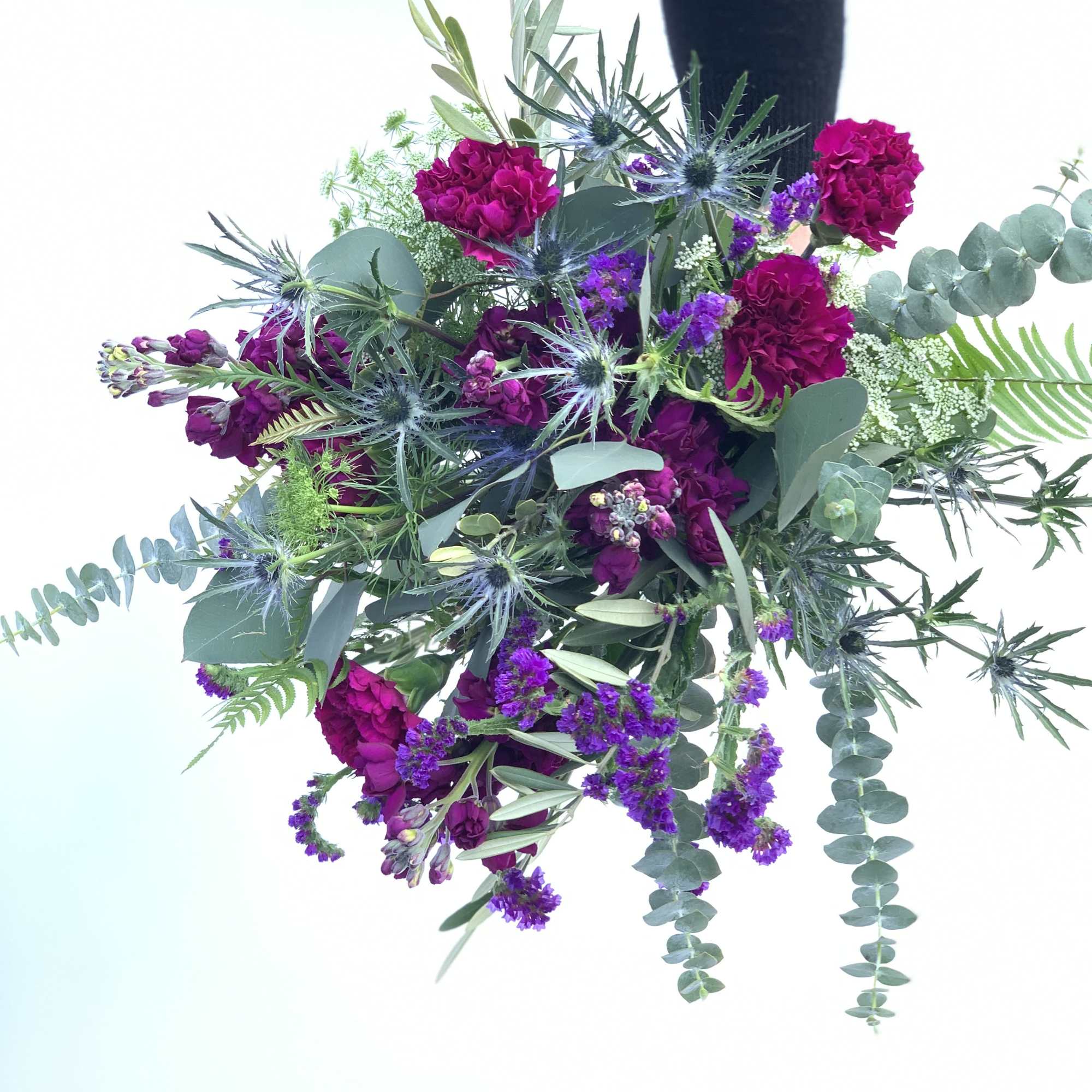Bouquet of magenta flowers with blue thistle and eucalyptus