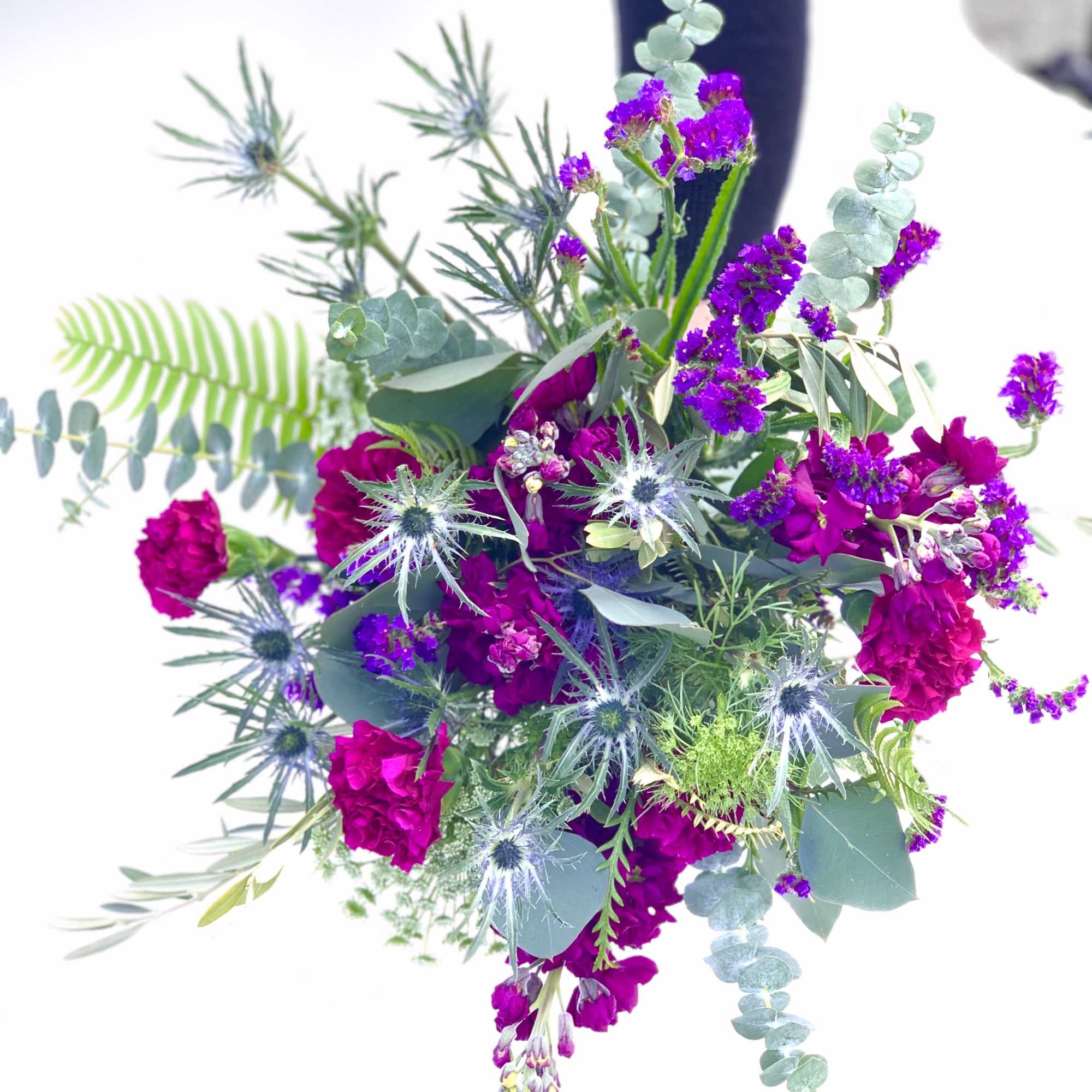 Bouquet of magenta flowers with blue thistle and eucalyptus