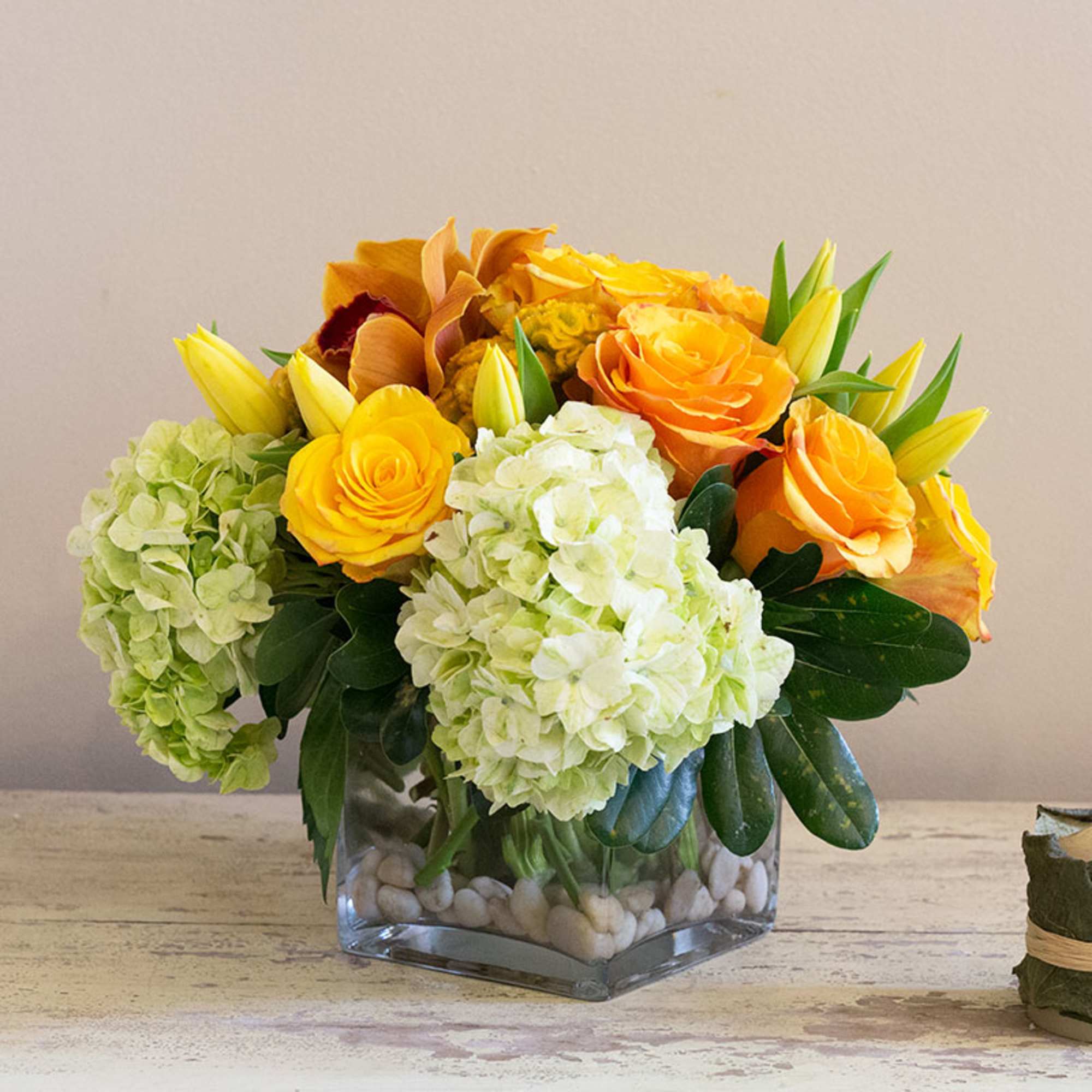 Bouquet of yellow roses and pale hydrangeas in a glass vase
