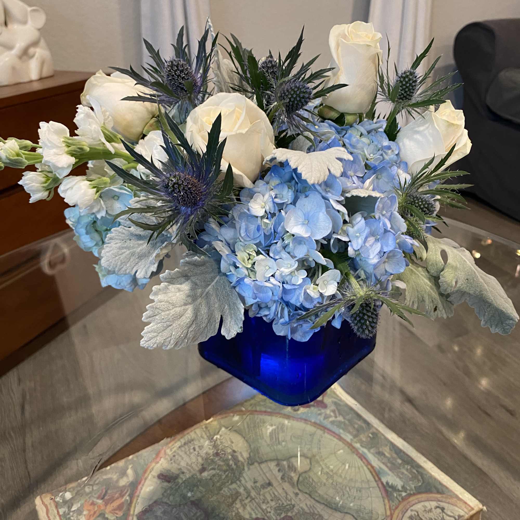 Blue hydrangeas and white roses in a cobalt vase