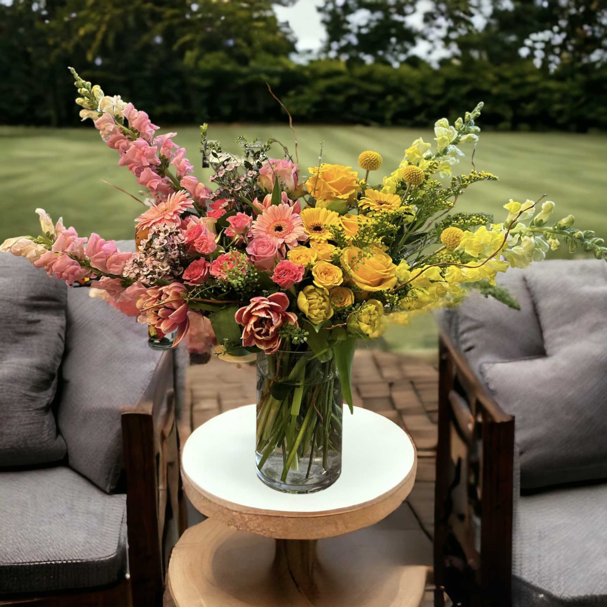 Colorful mixed bouquet in a clear glass vase on a small table