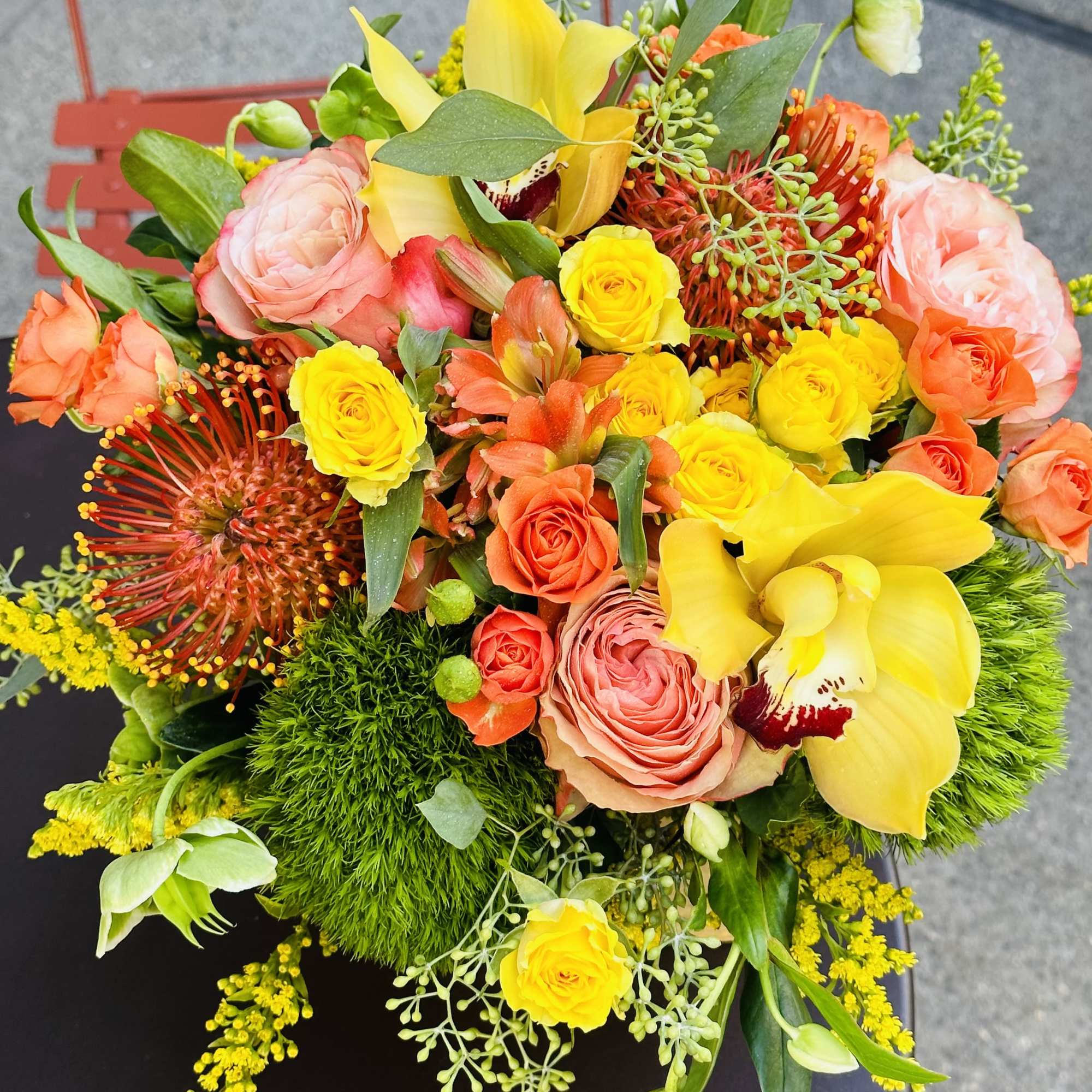 Bright bouquet of yellow and coral flowers with pink roses