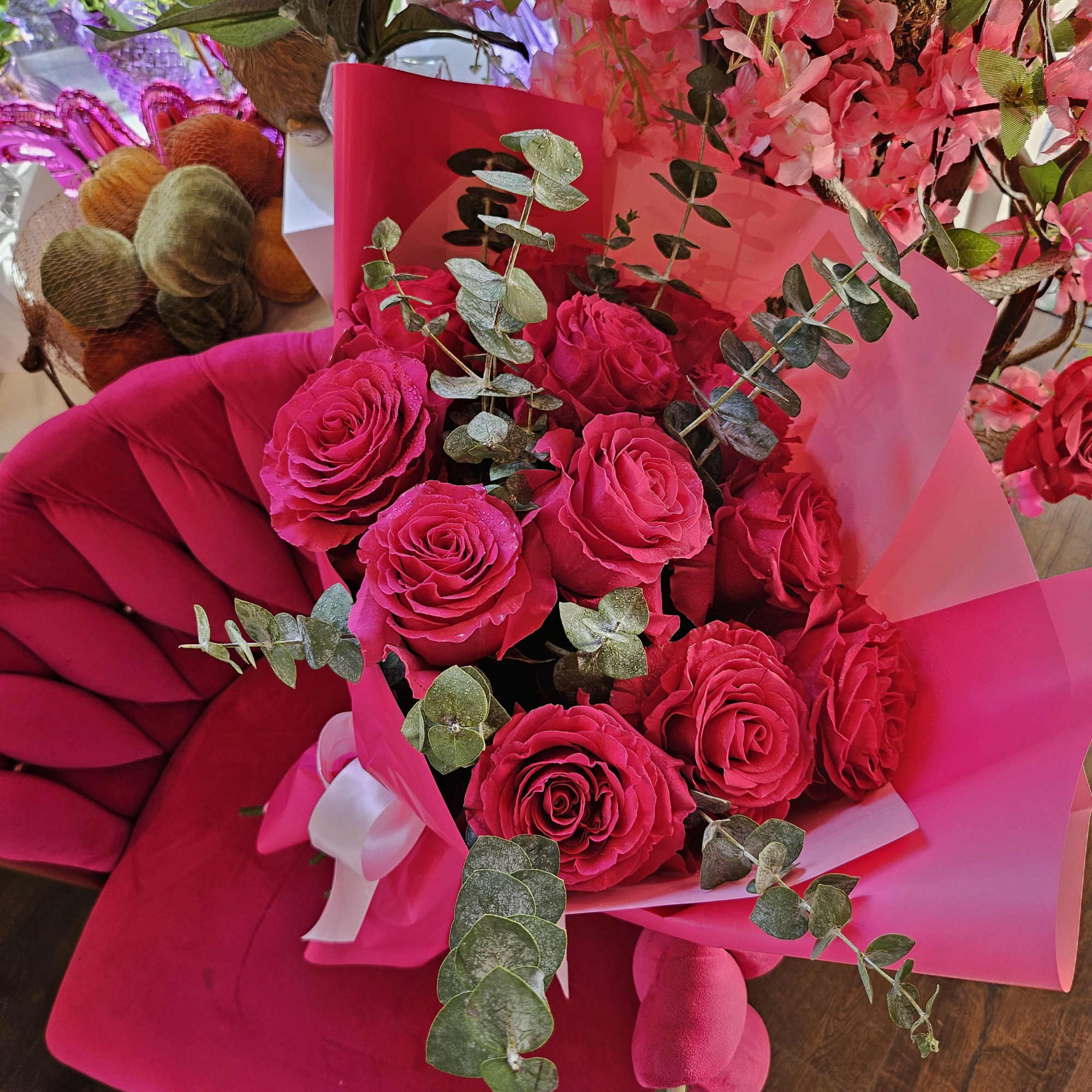 Bouquet of hot pink roses with eucalyptus in pink wrapping