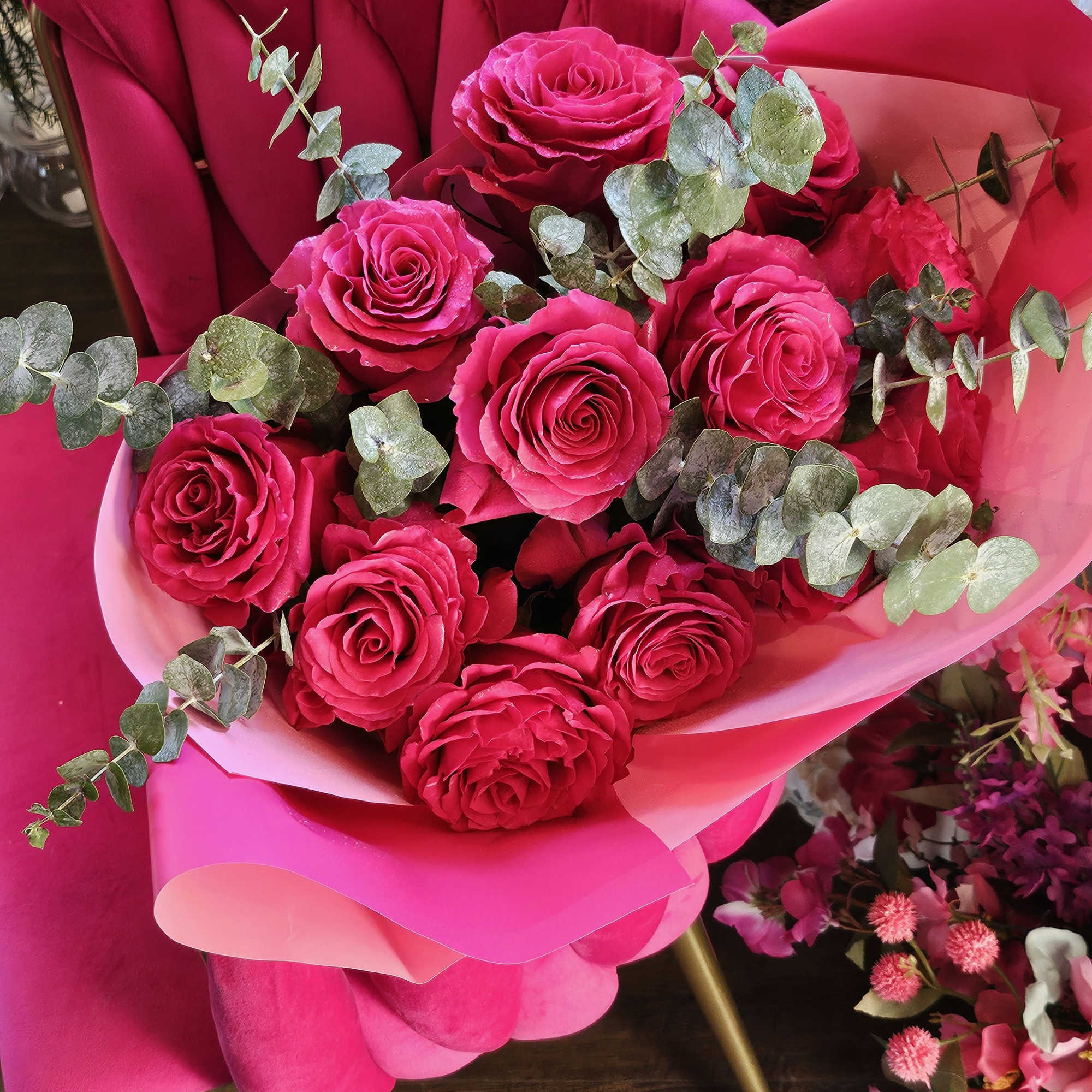 Bouquet of hot pink roses with eucalyptus in pink wrapping