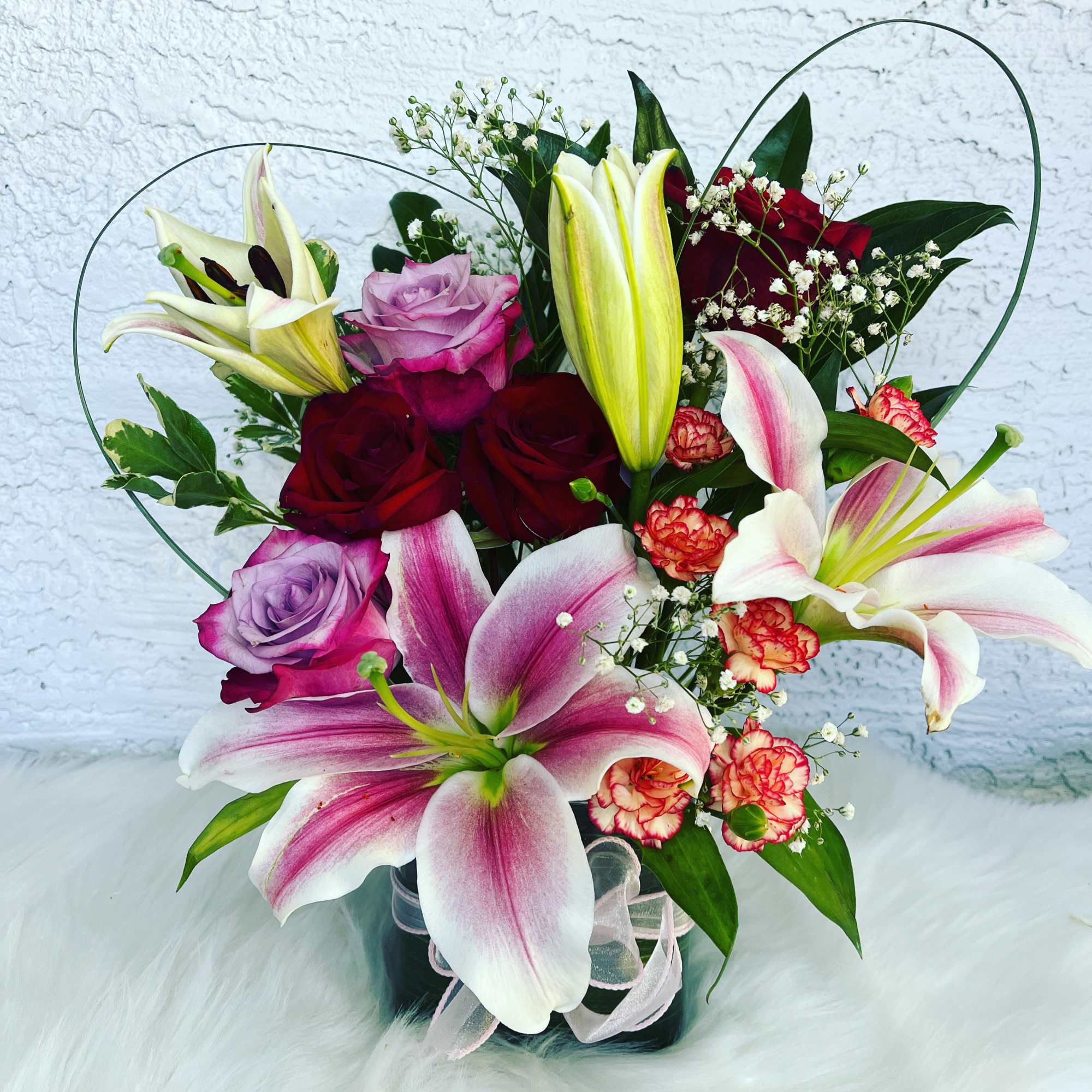Mixed bouquet of lilies, roses, and carnations in a vase