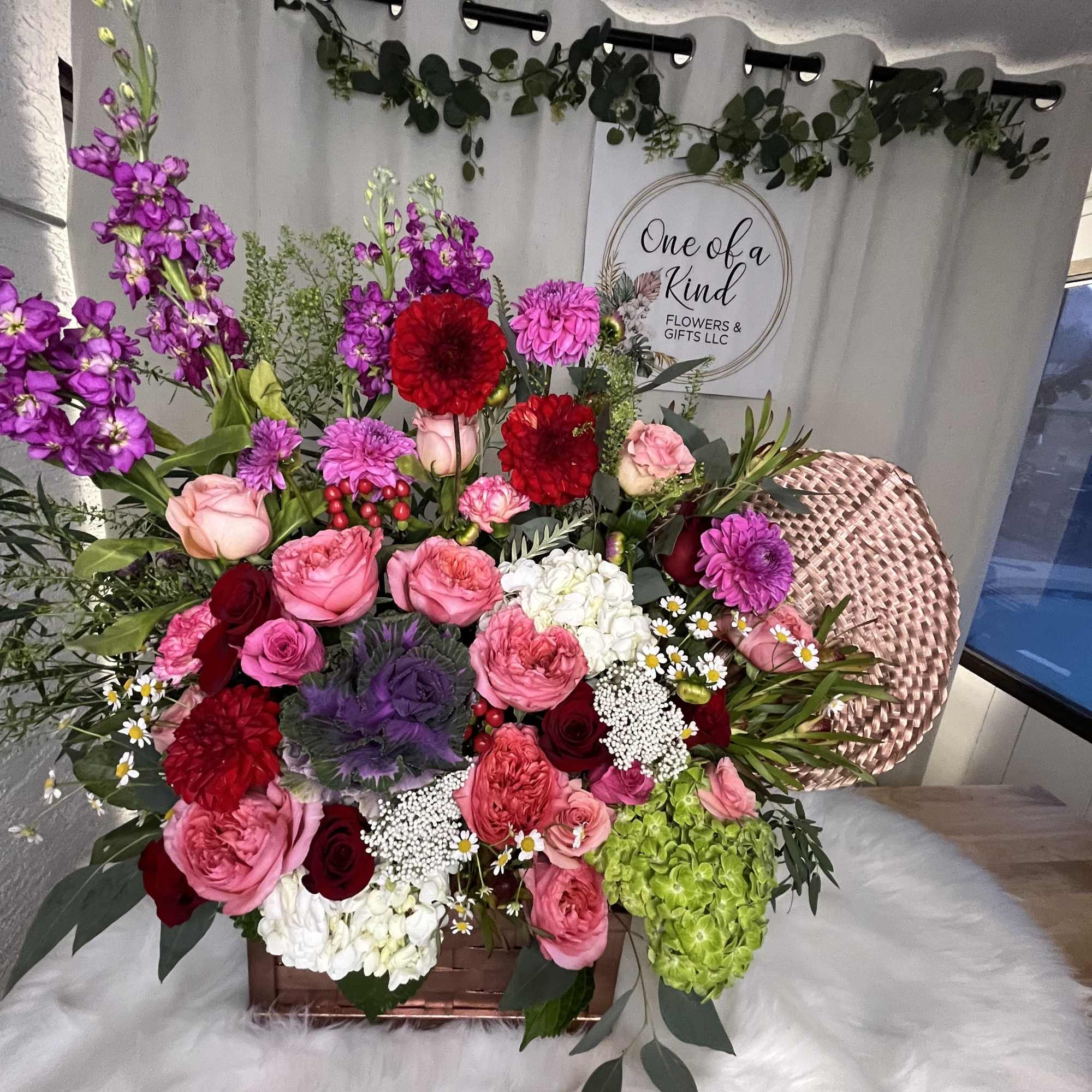 Mixed bouquet in a basket with pink, red, white, and purple flowers