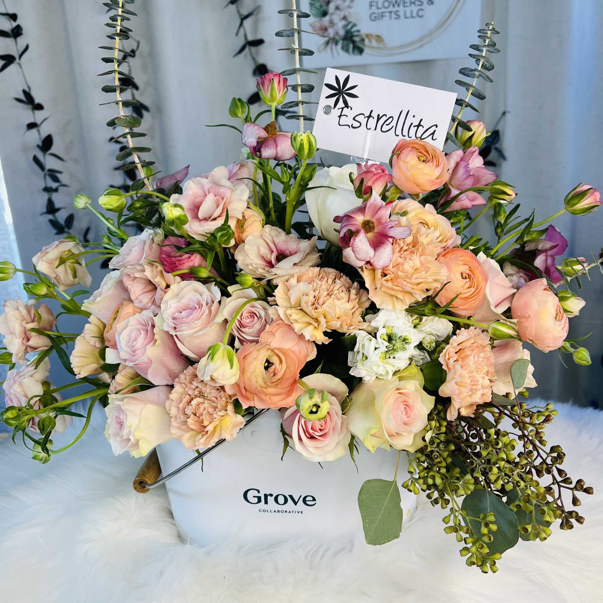 Pastel bouquet of roses, ranunculus, and carnations in a white box