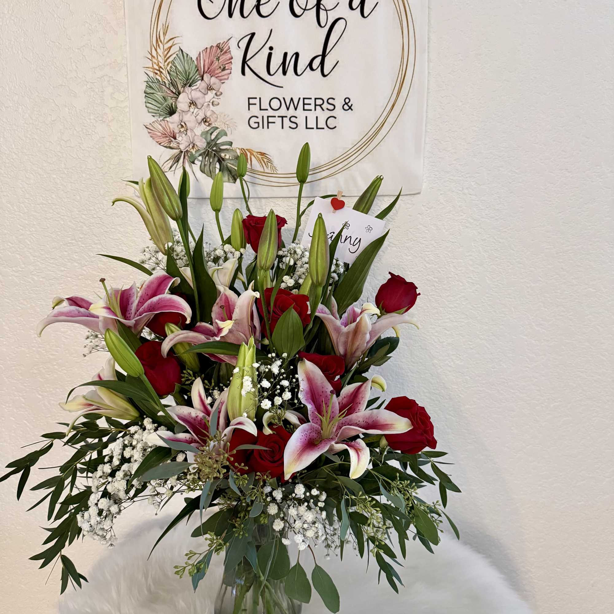 Bouquet of pink lilies and red roses in a glass vase