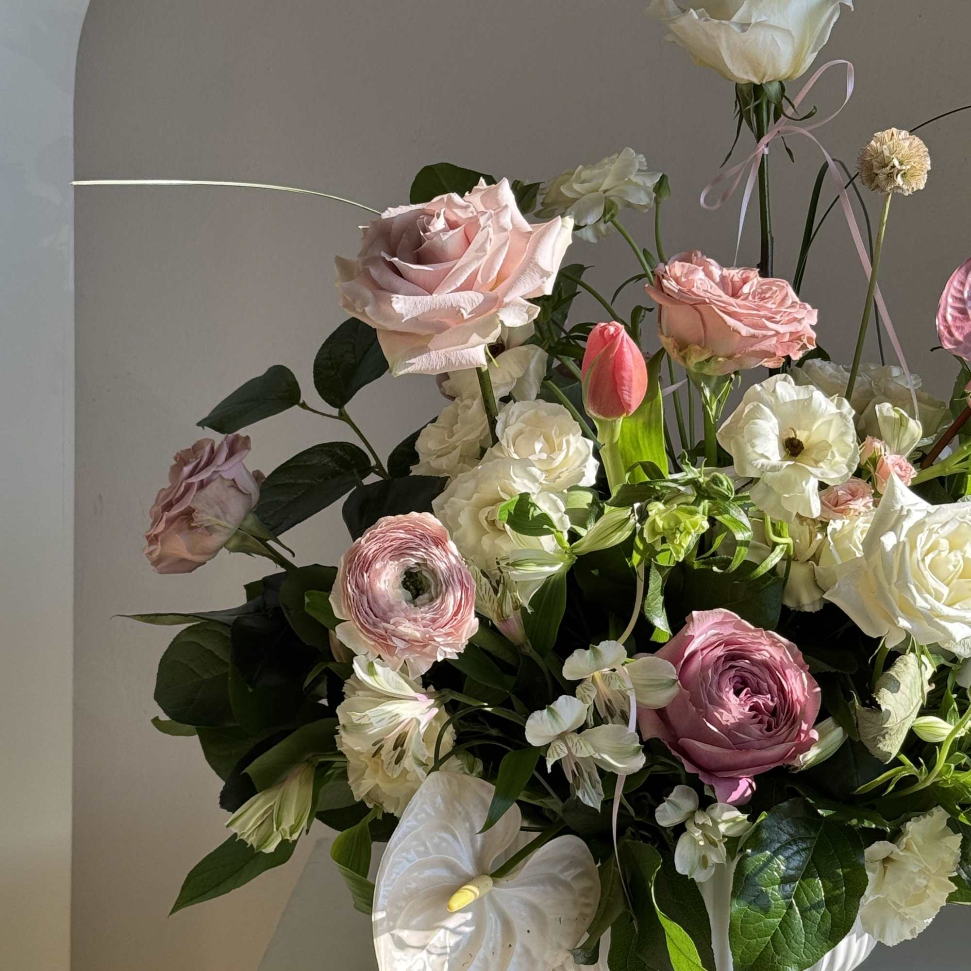 Pink and white floral arrangement in a white vase
