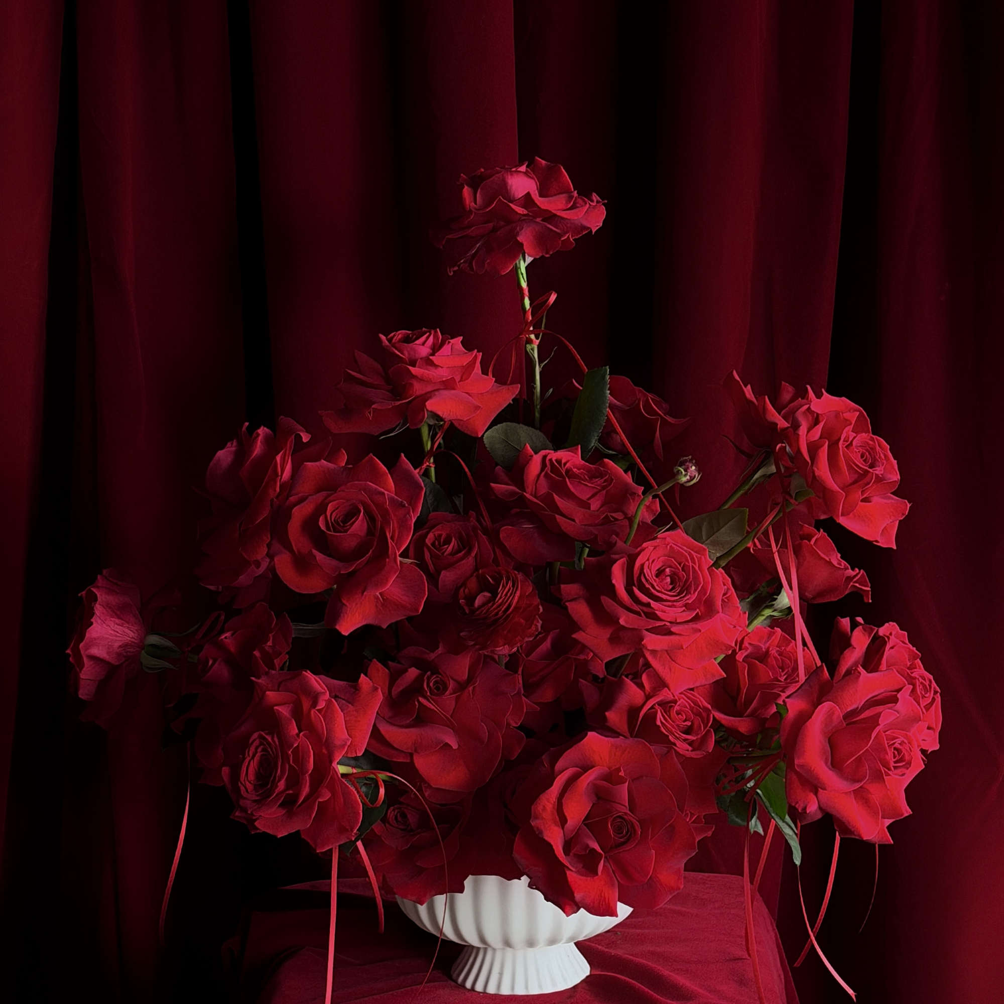 Designed for falling in love.
Layers of red roses and ranunculus,
wrapped in pure