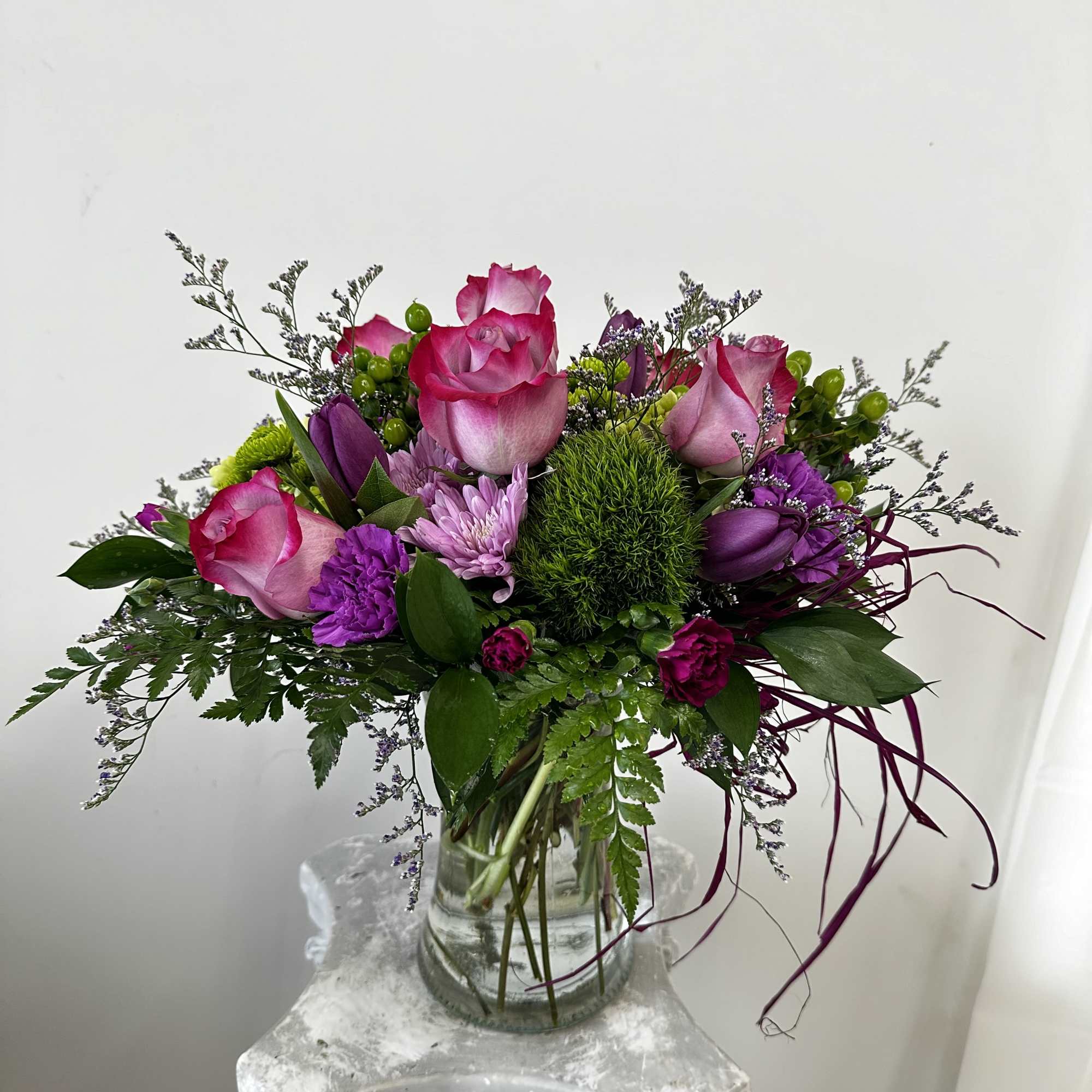 Pink and purple rose bouquet in a clear glass vase