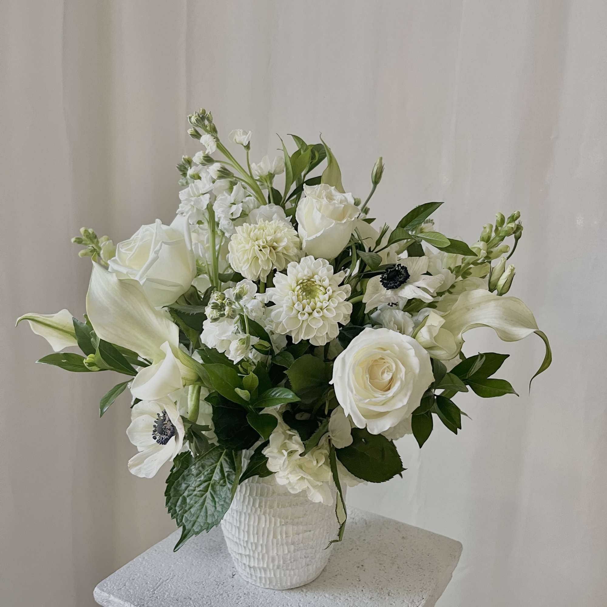 White floral arrangement in a textured white vase