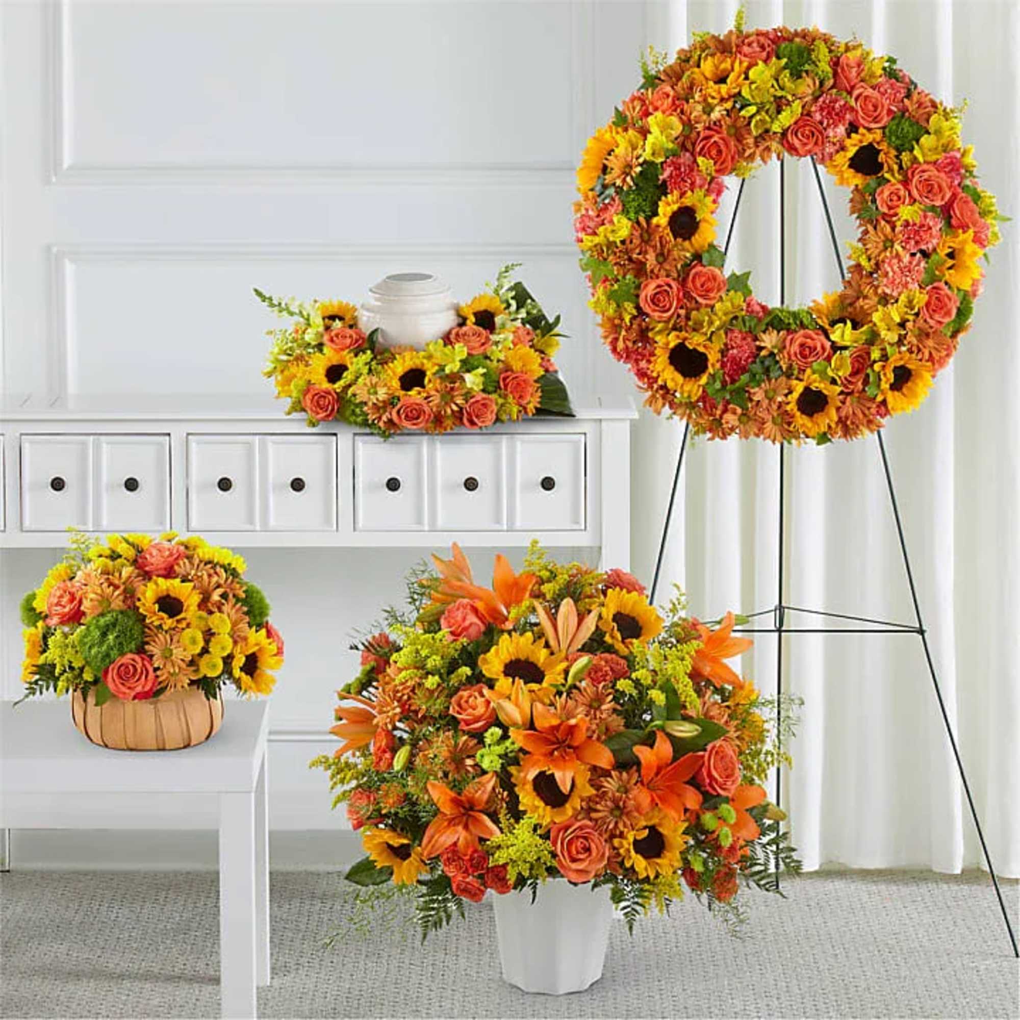 Bright orange and yellow floral funeral tribute with a wreath and arrangements