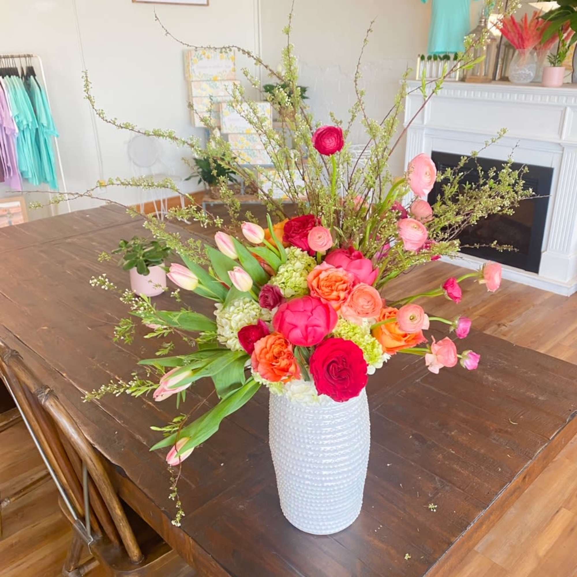 Tall mixed bouquet in a white textured vase with pink and orange flowers