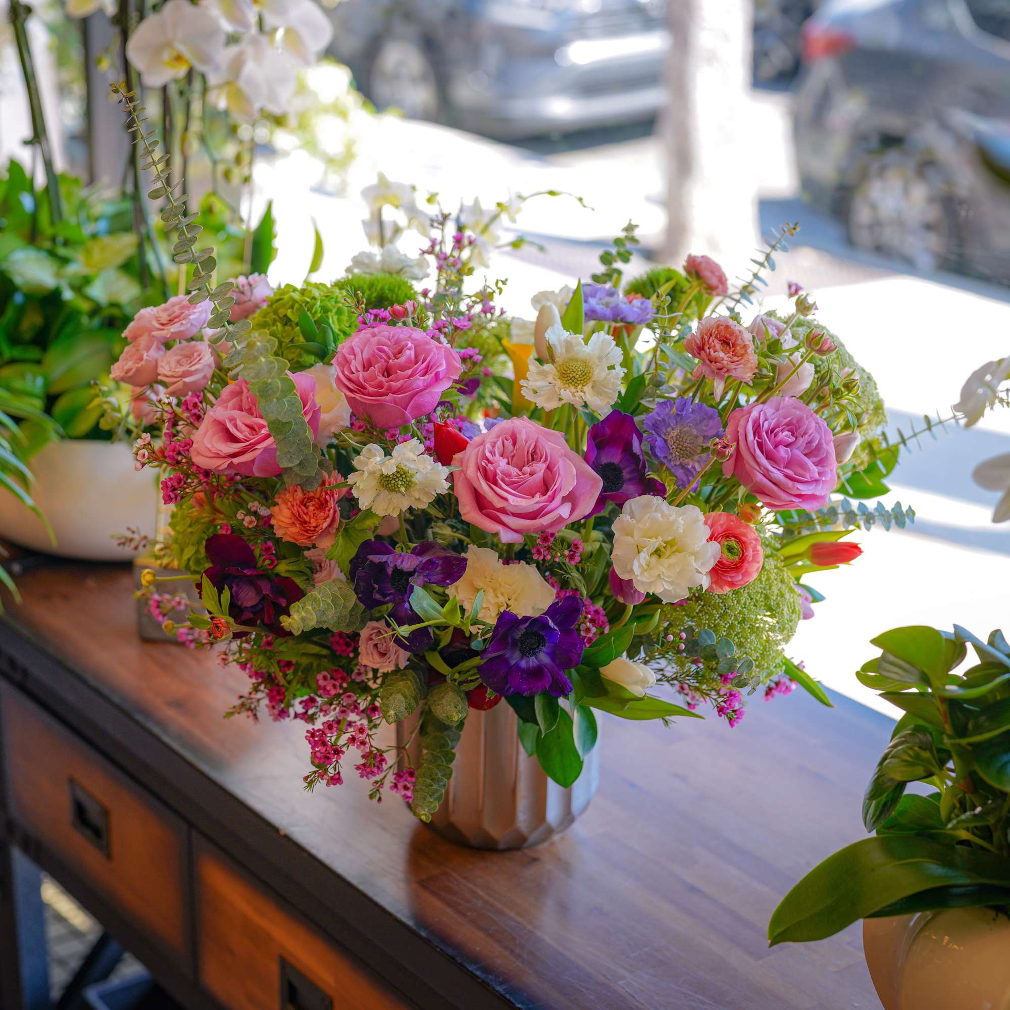A luxurious garden-style flower arrangement featuring soft pink roses, delicate seasonal blooms