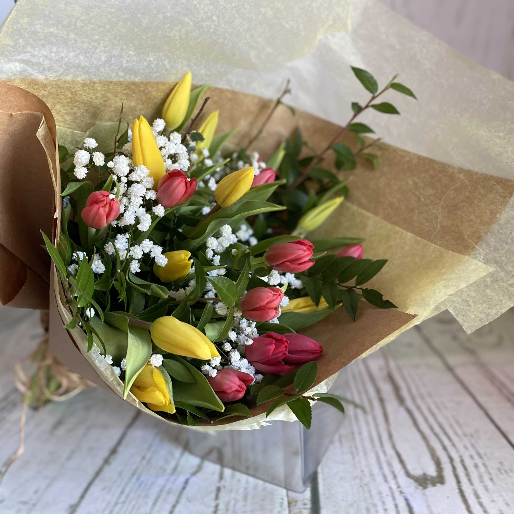 Bouquet of yellow and pink tulips with white filler flowers