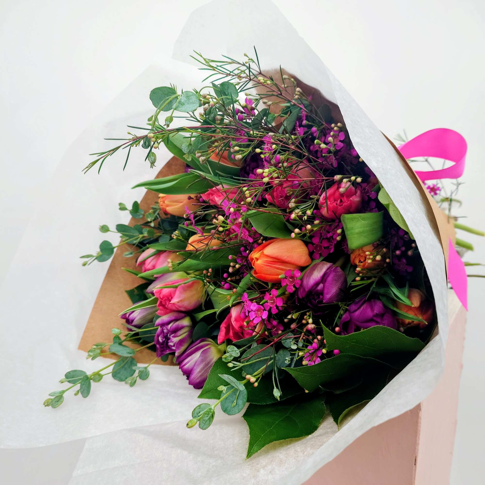 Bouquet of multicolored tulips wrapped in white paper