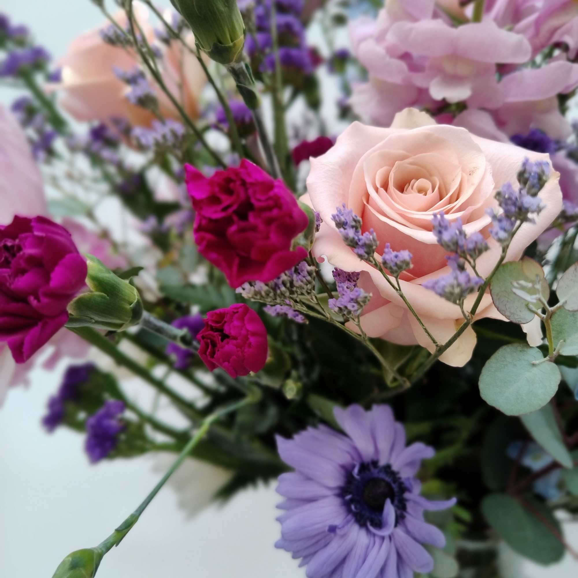 Bouquet of pink roses, purple blooms, and lavender flowers