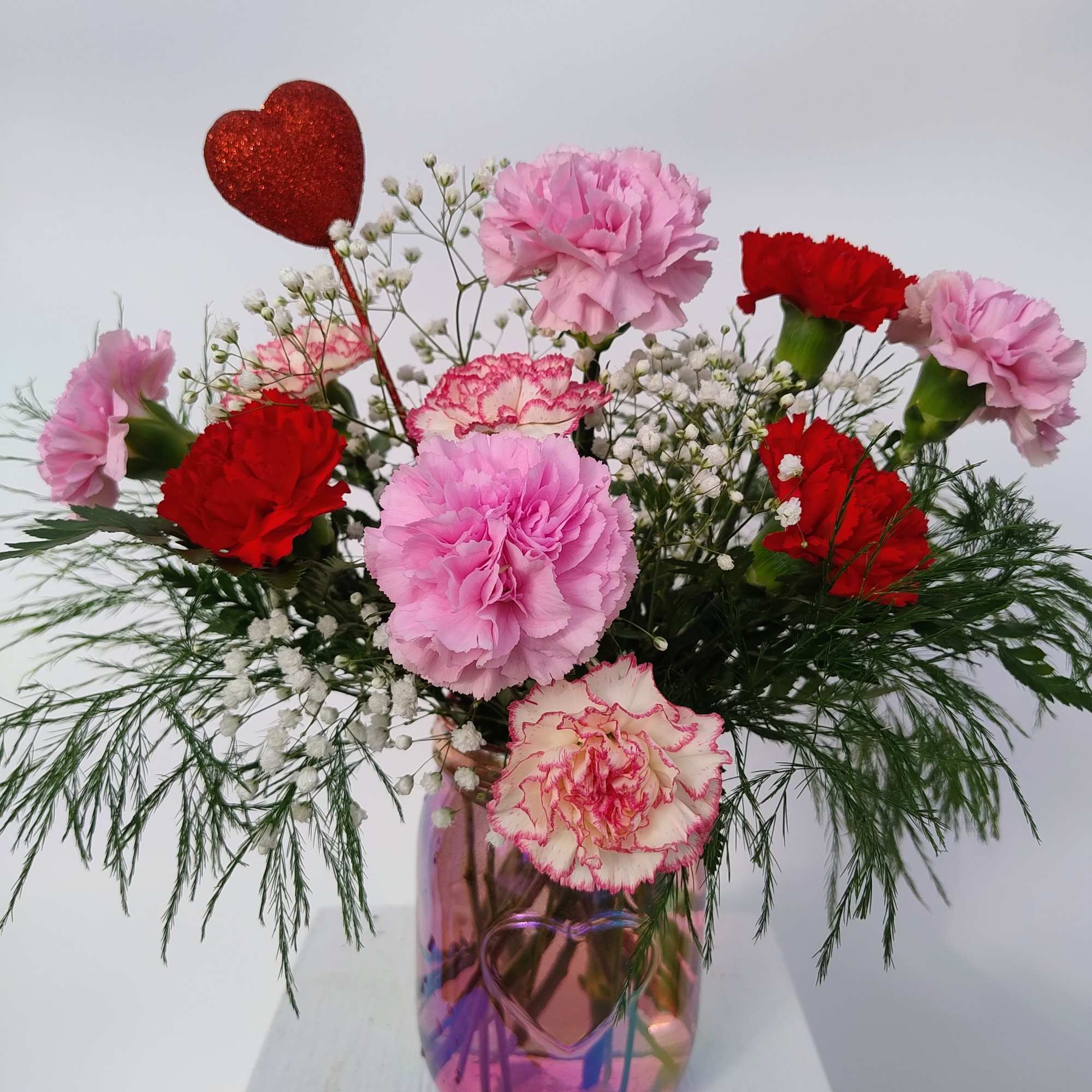 This keepsake iridescent pink mason jar with an embossed heart is filled