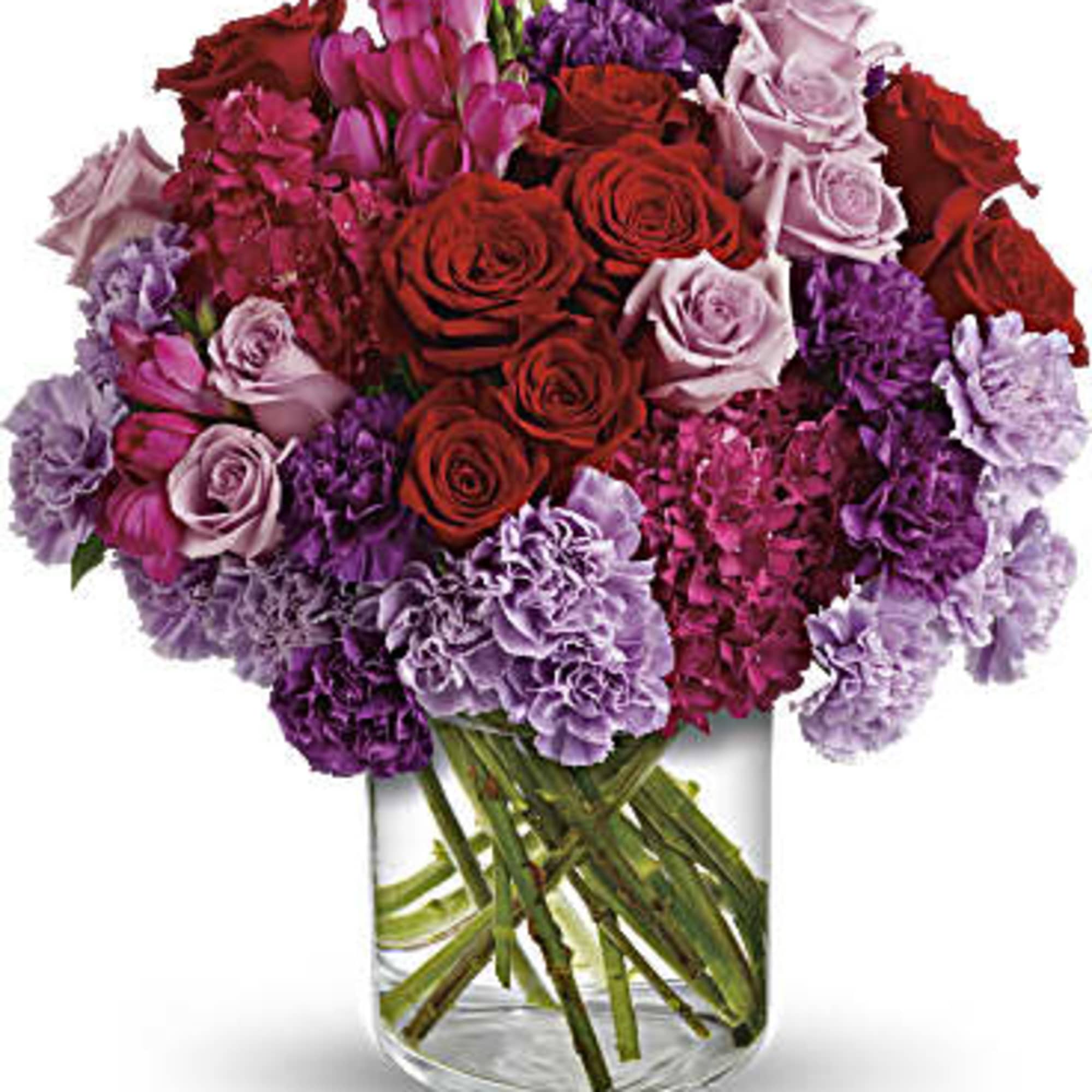 Bouquet of red, pink, and purple flowers in a clear glass vase