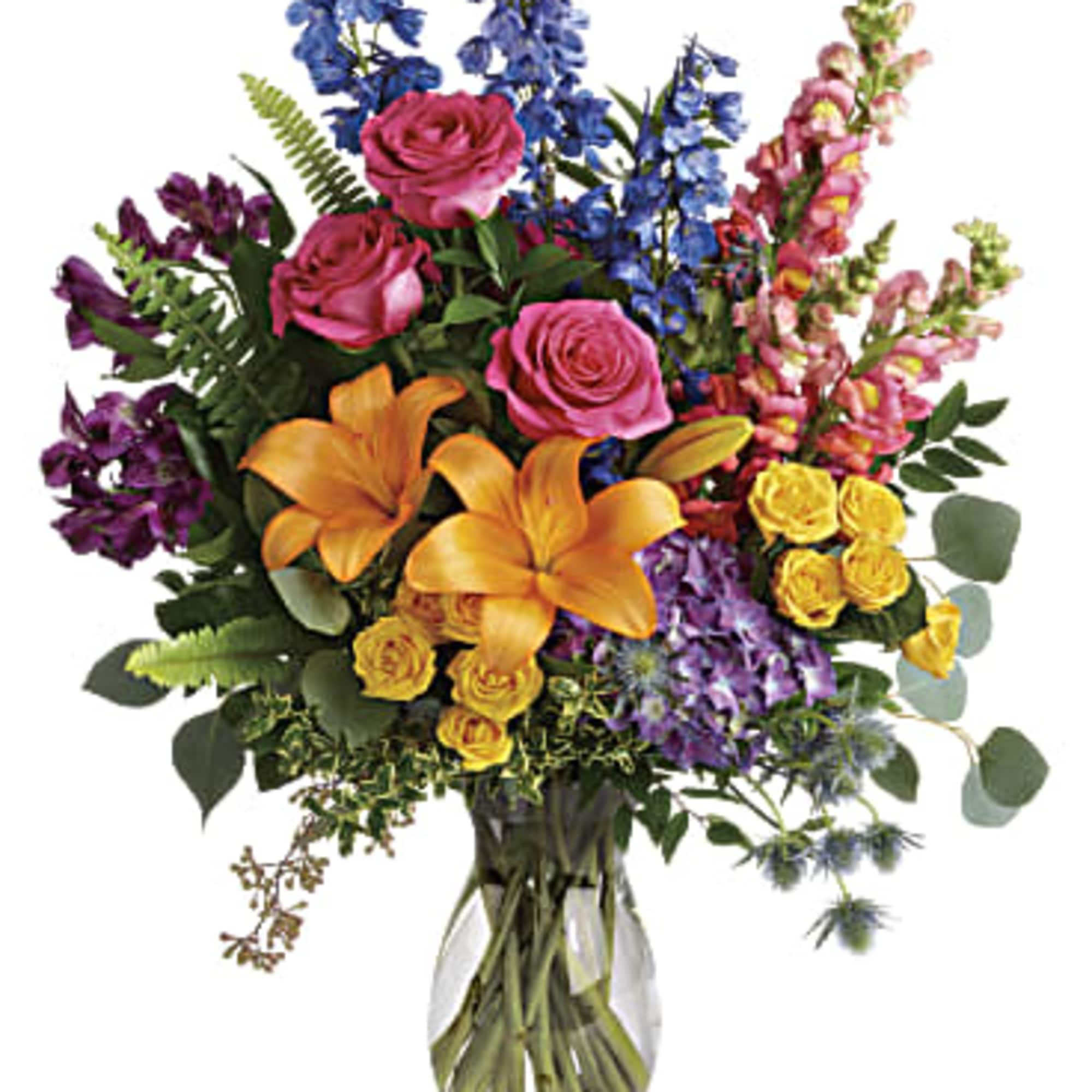 Tall mixed bouquet with pink roses, orange lilies, blue delphinium, and yellow spray roses in a clear glass vase