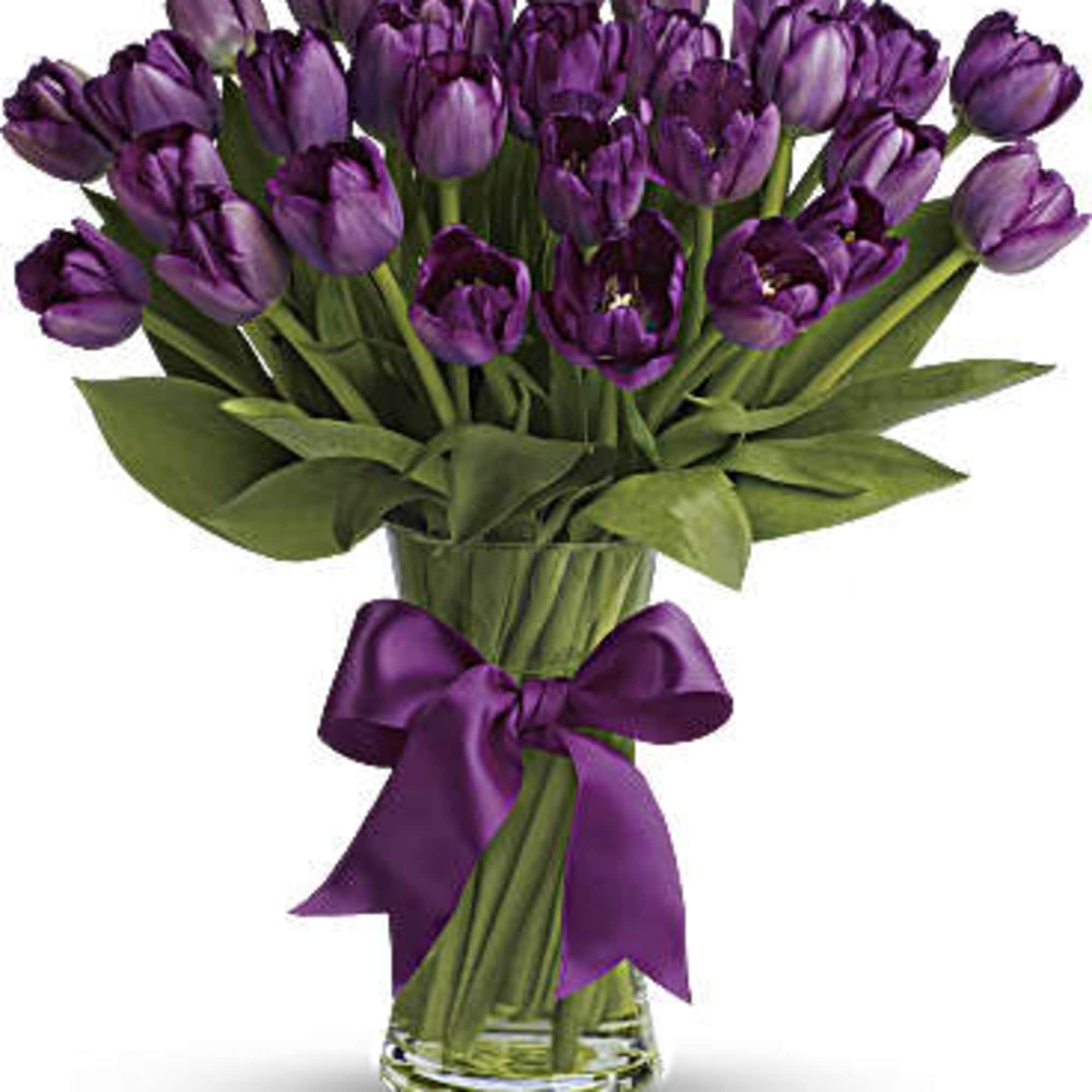 Purple tulip bouquet in a clear glass vase with a satin ribbon