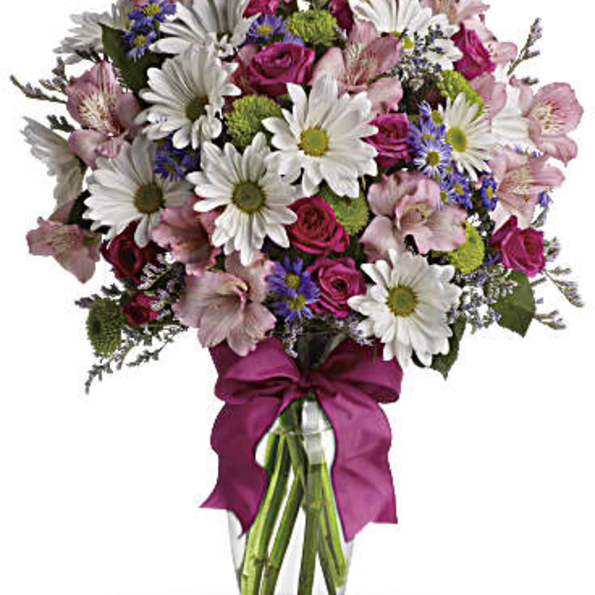 Mixed bouquet of daisies, roses, and pink flowers in a glass vase with a ribbon
