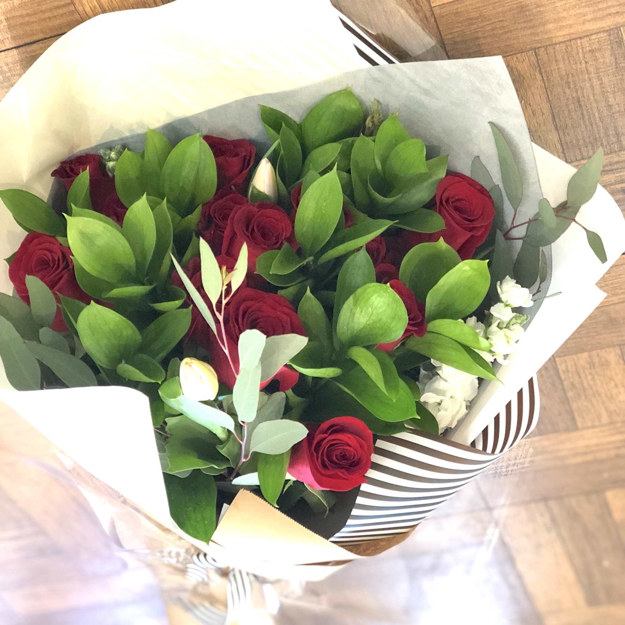 Dozen of premium red roses and touch of seasonal blooms. Deluxe wrapping.