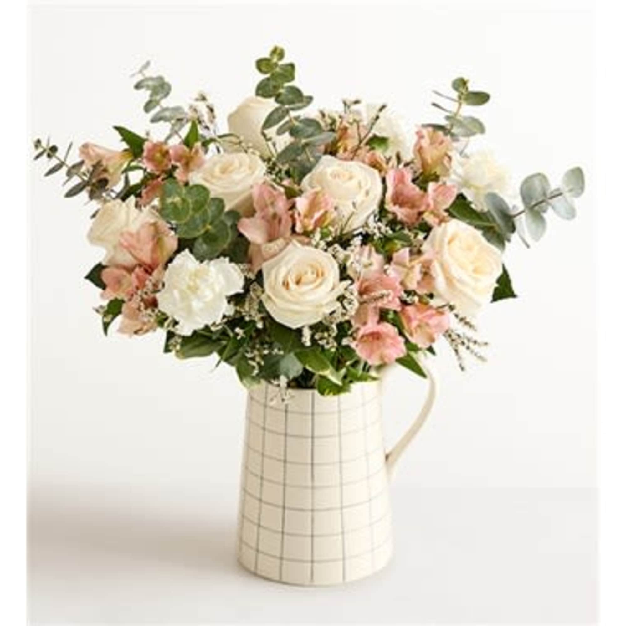 Cream and blush bouquet in a white checked pitcher vase