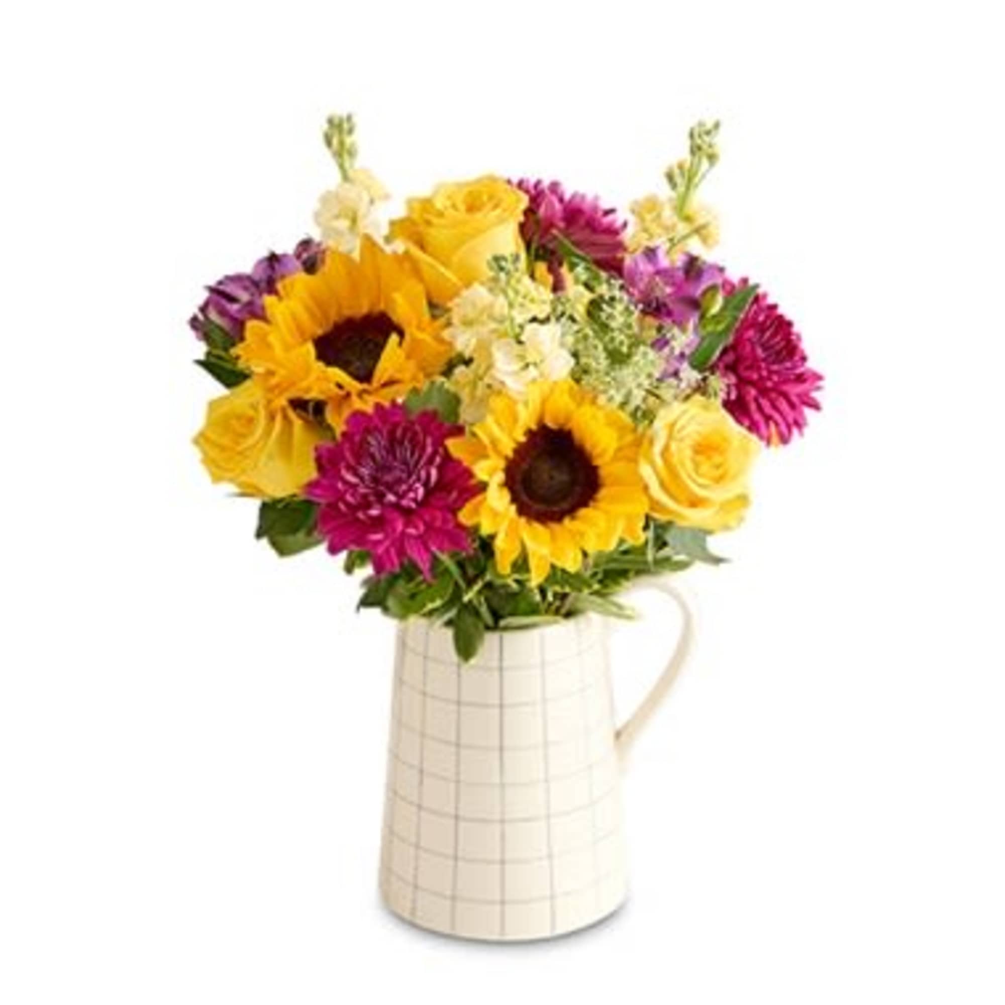 Bouquet of sunflowers, yellow roses, and magenta blooms in a cream pitcher