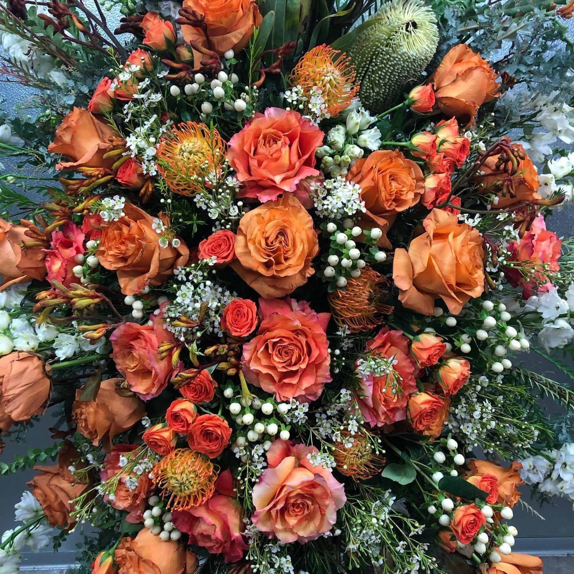 Large bouquet of orange roses with mixed accent flowers
