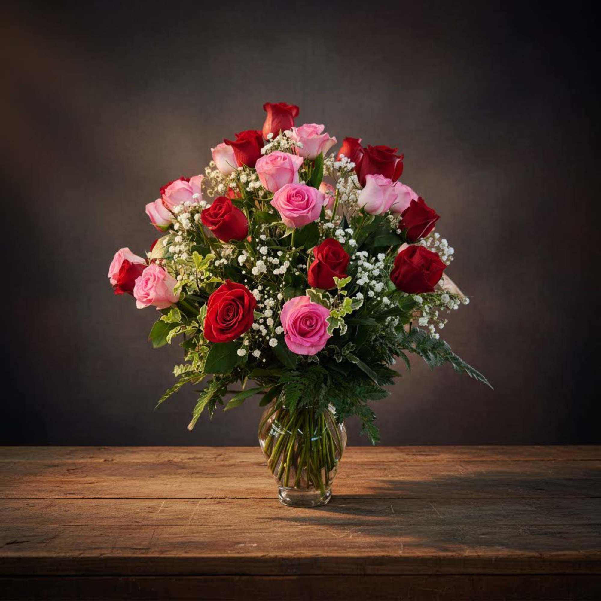 Bouquet of red and pink roses in a clear glass vase