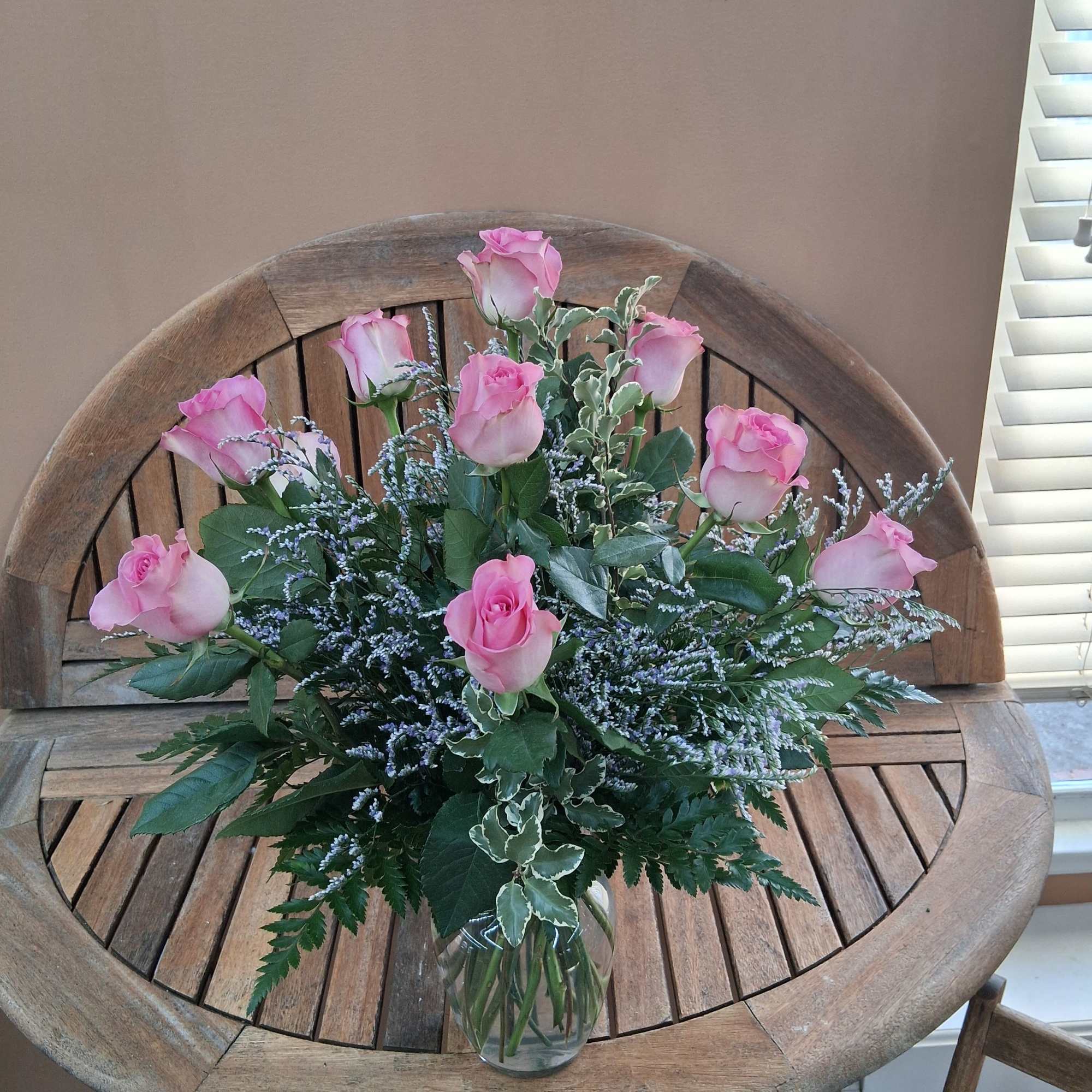Pink roses arranged in a clear glass vase