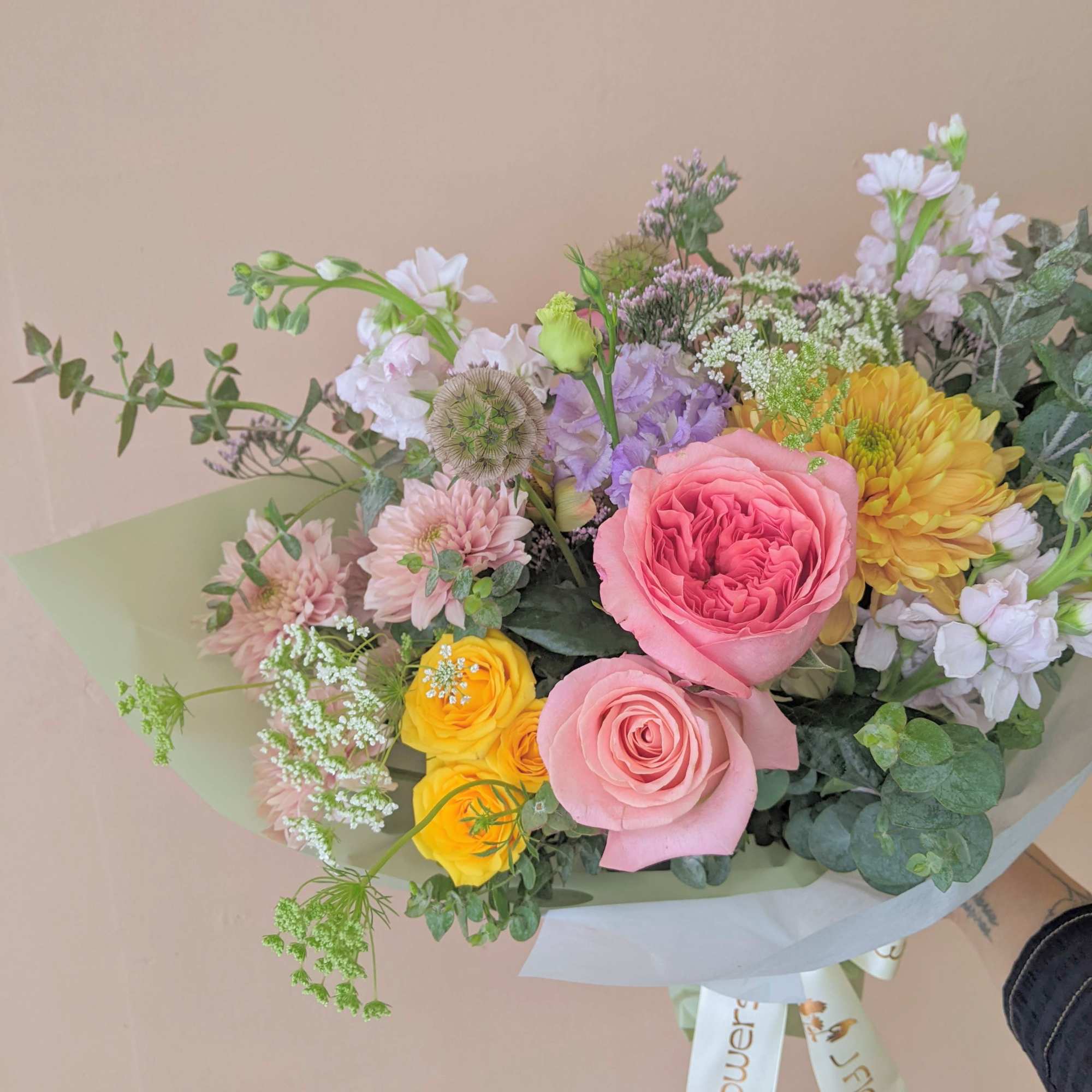 Mixed bouquet with pink and yellow roses and pastel flowers