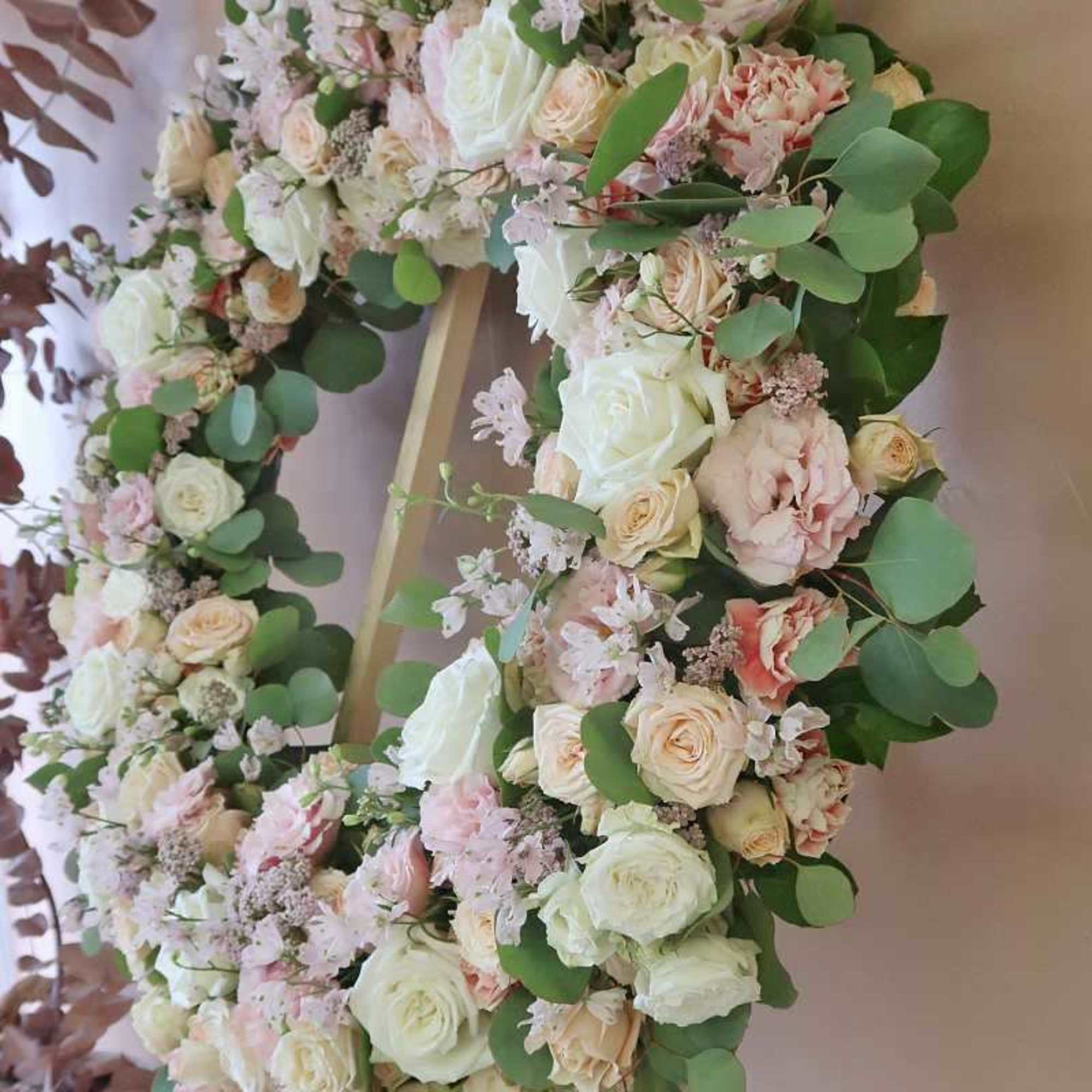 Heart-shaped floral wreath with white and blush roses and greenery