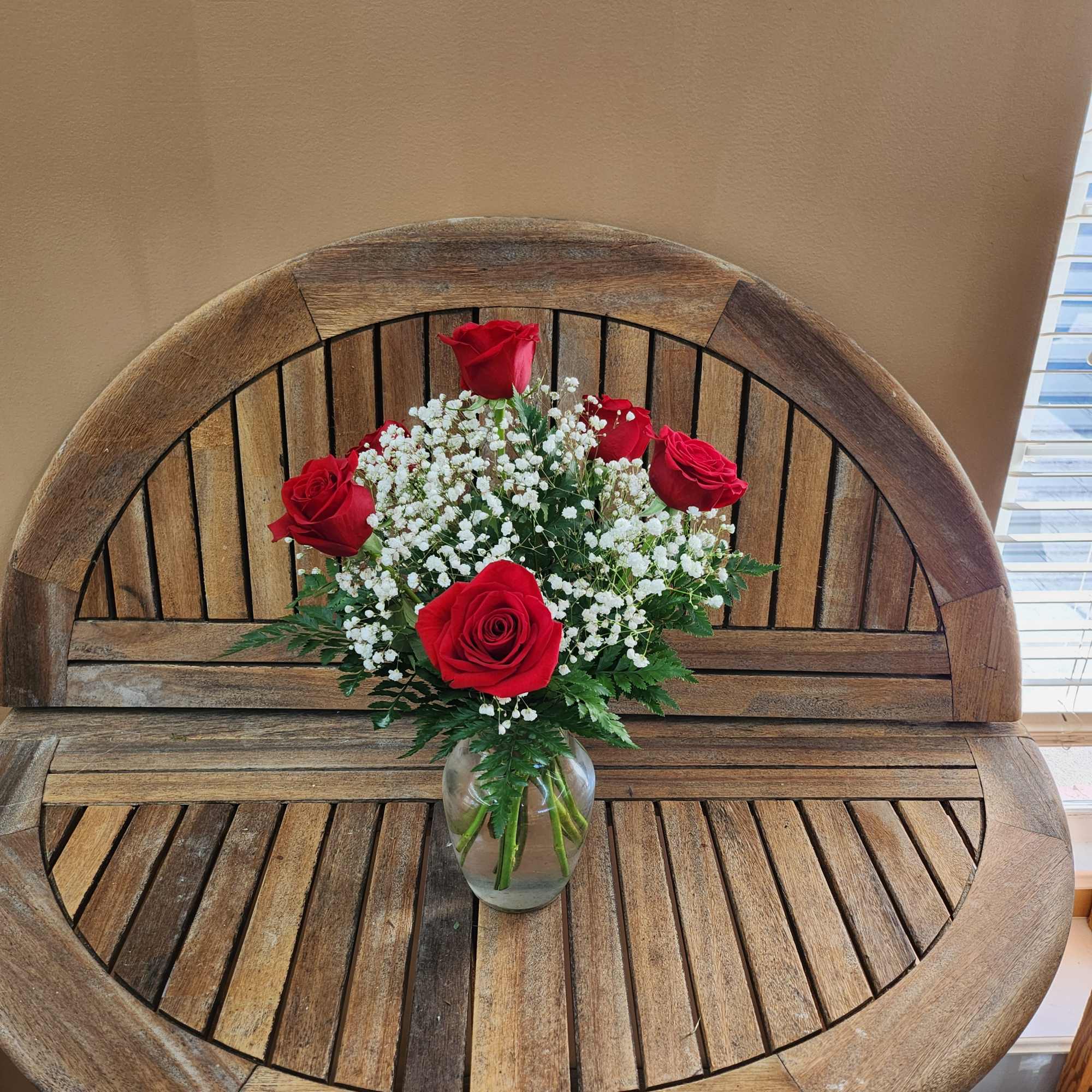 Red roses and white baby's breath in a clear glass vase