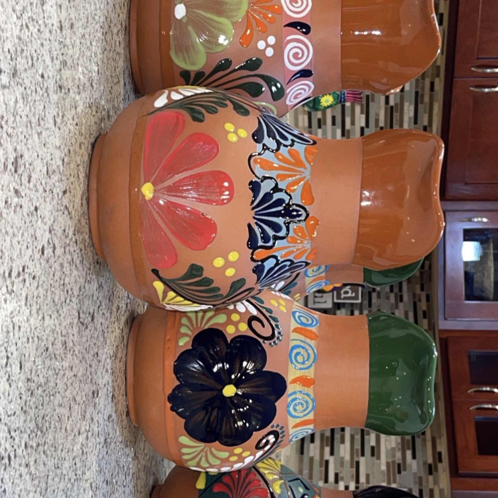 Painted terracotta pots with colorful floral and butterfly designs