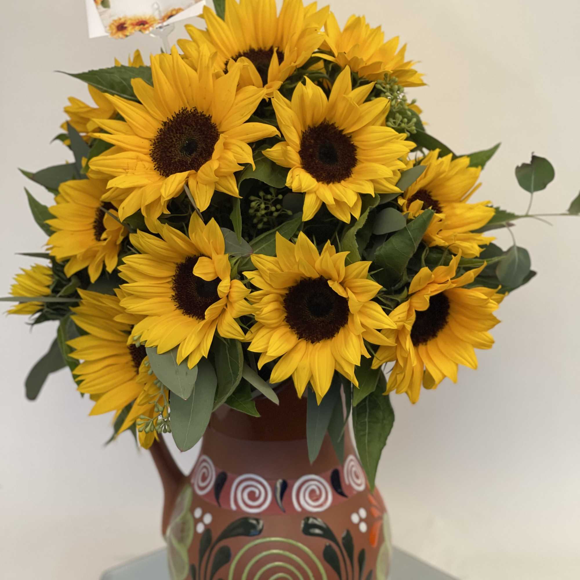 Bouquet of yellow sunflowers in a painted ceramic vase
