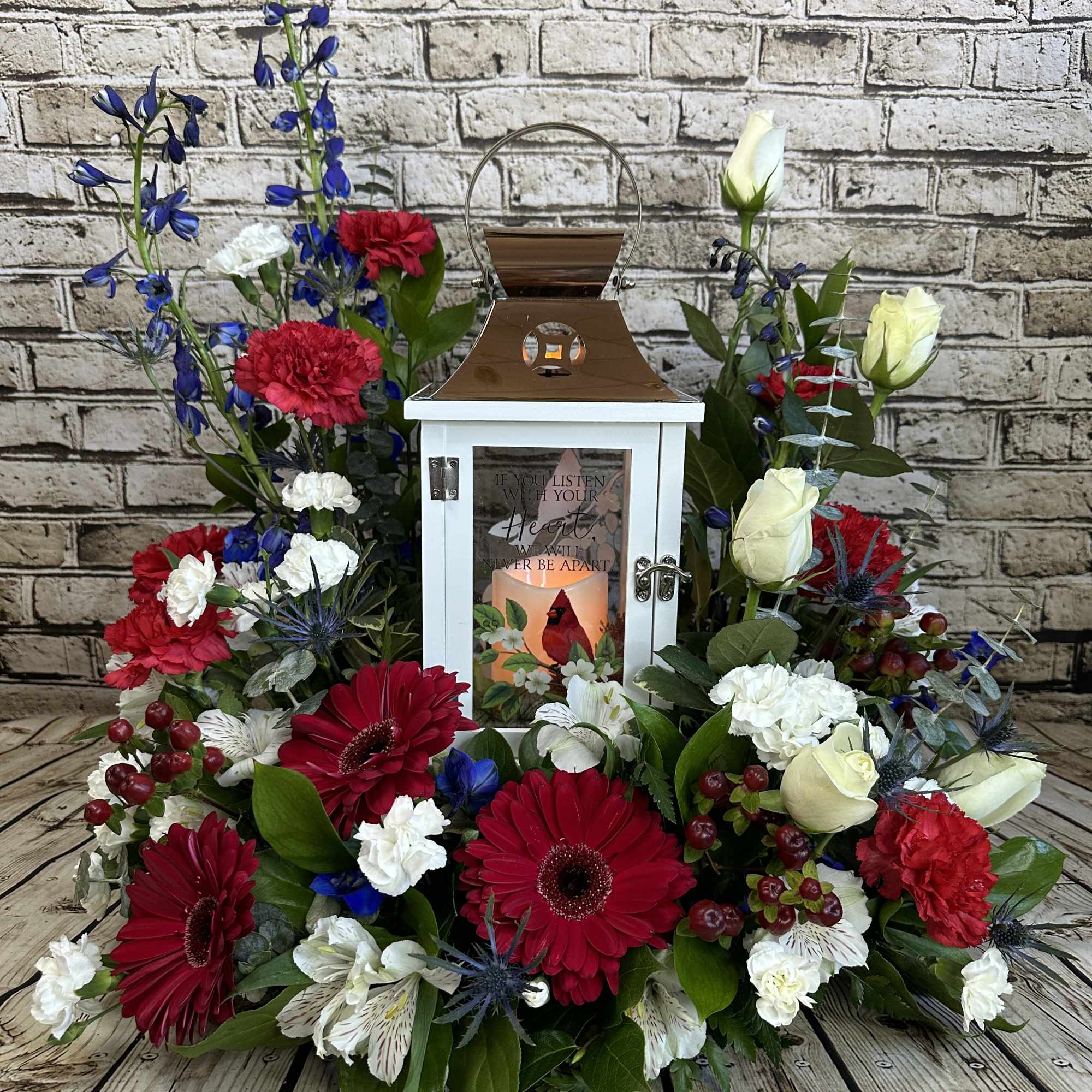 Floral wreath around a white lantern with red, white, and blue flowers