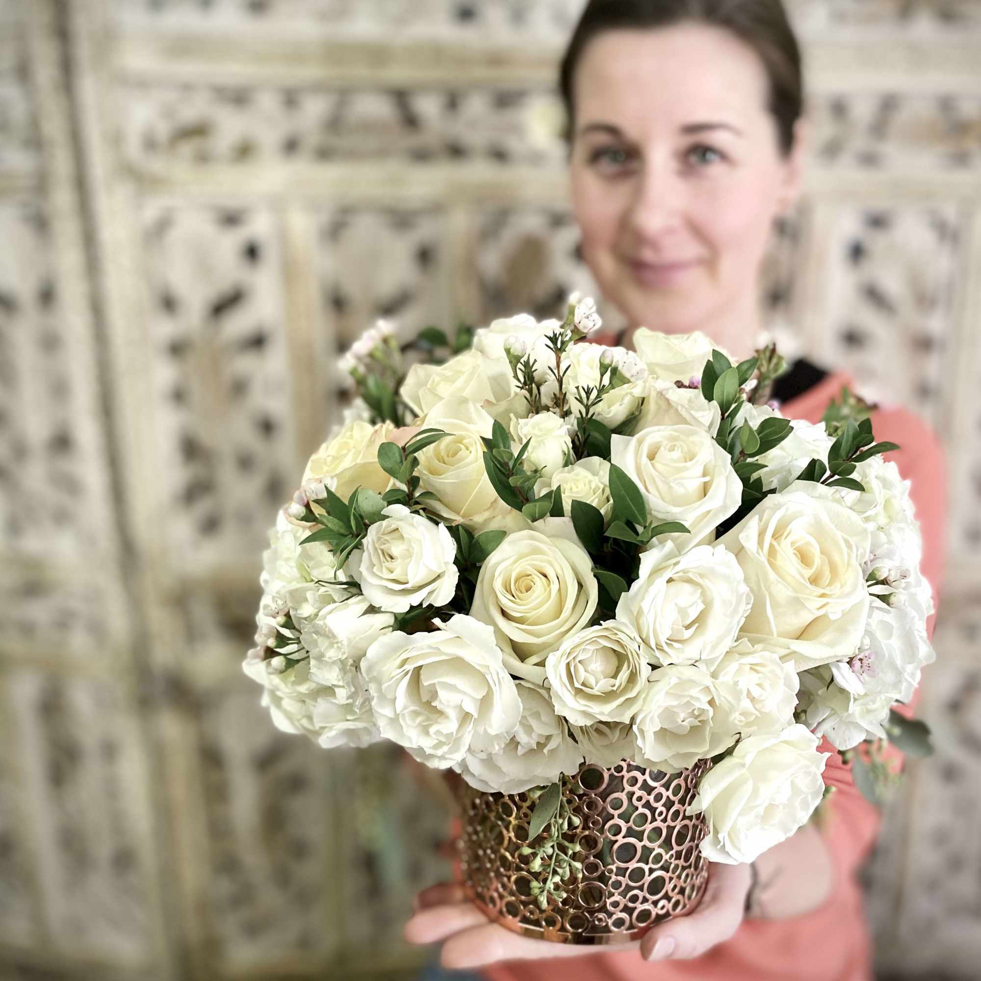 White rose bouquet in a decorative metal vase