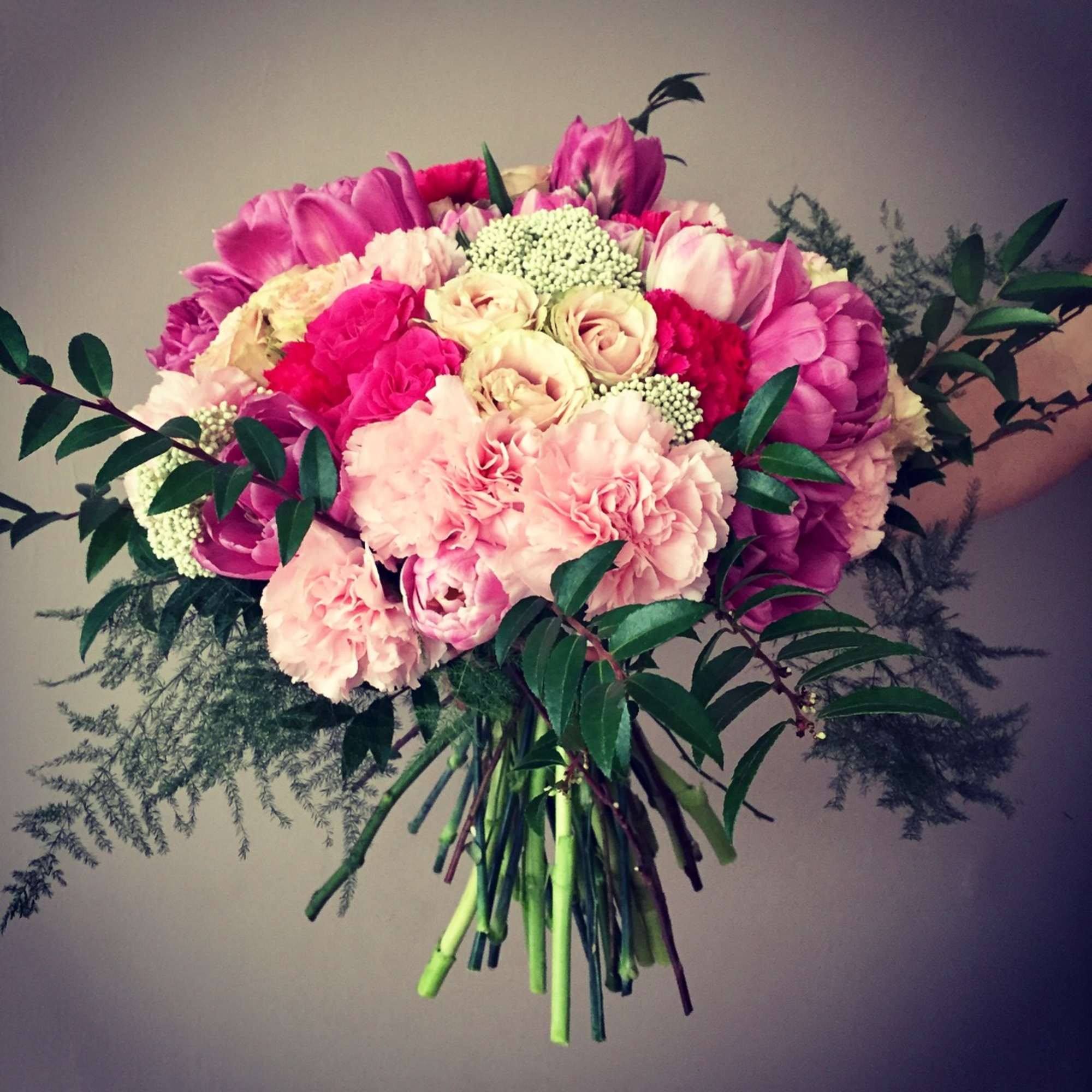 Hand-tied bouquet of pink and cream flowers with greenery