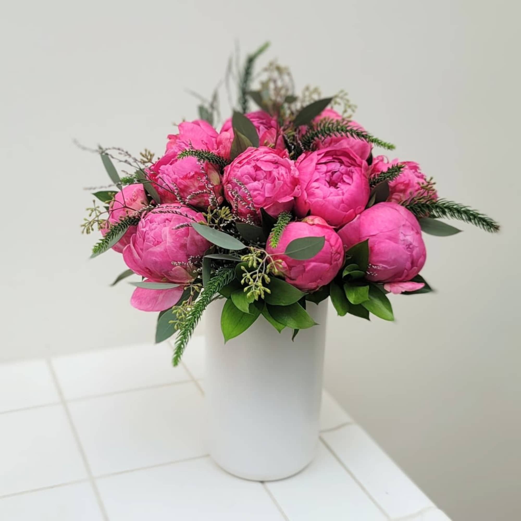 Pink peony bouquet in a white vase