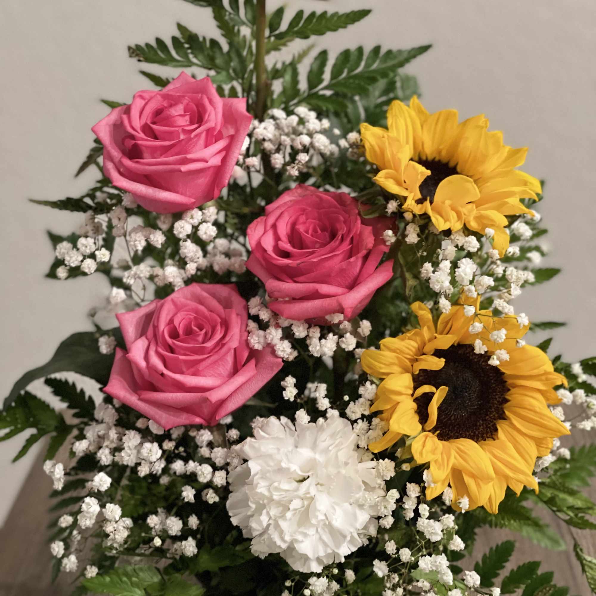 Pink roses and sunflowers with white filler flowers in a bouquet