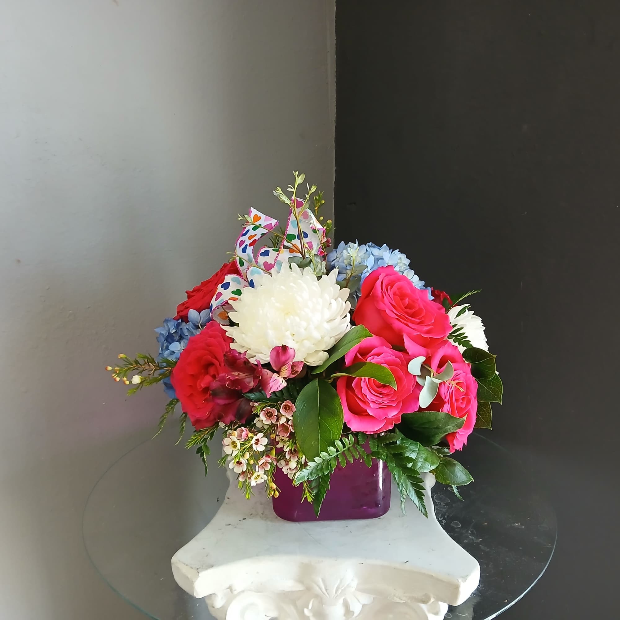 This beautiful flower arrangement of fresh mixed seasonal blooms is made by