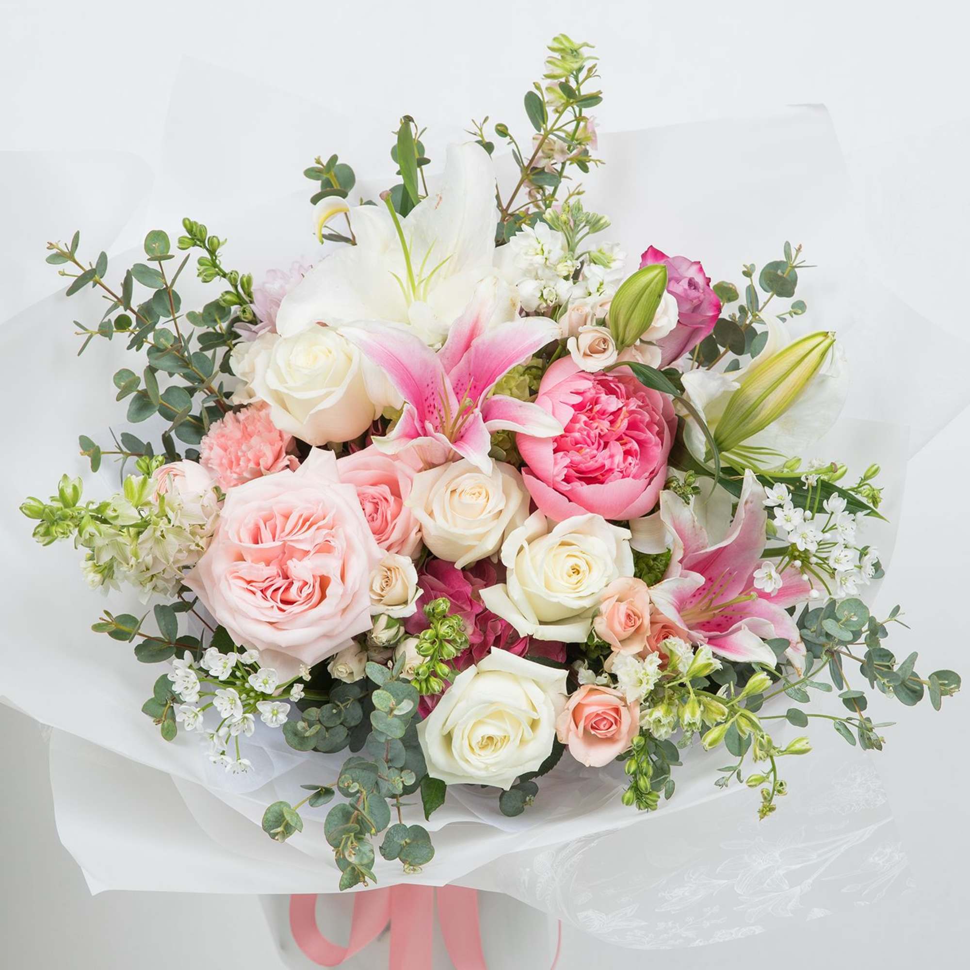 A beautiful mix of soft pink and ivory seasonal blooms bouquet, thoughtfully