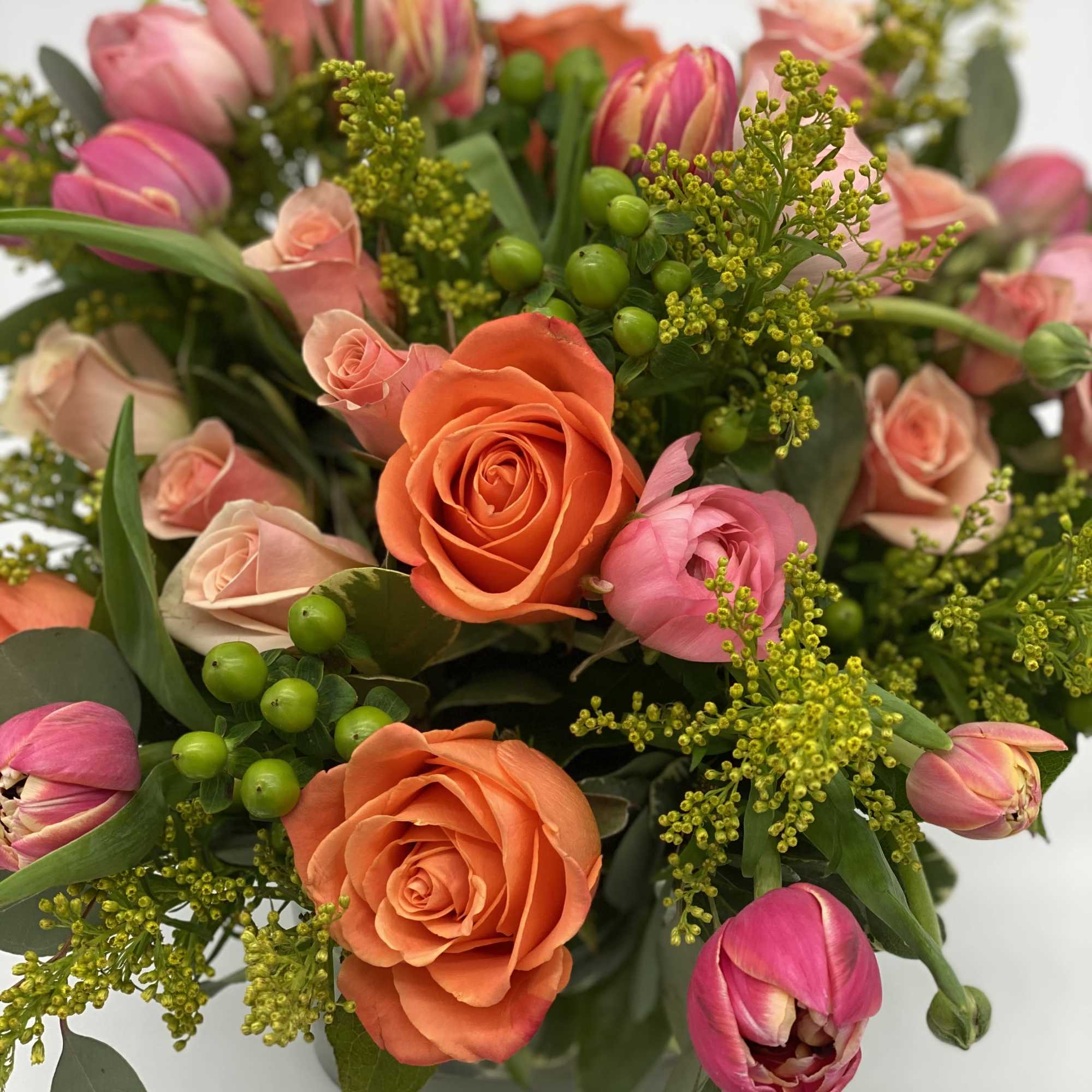 Bouquet of orange and pink roses with pink tulips