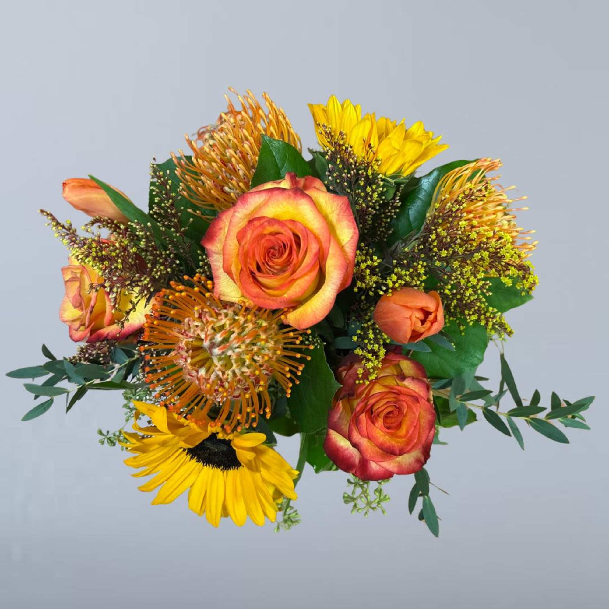 Bouquet of orange roses and yellow flowers with greenery