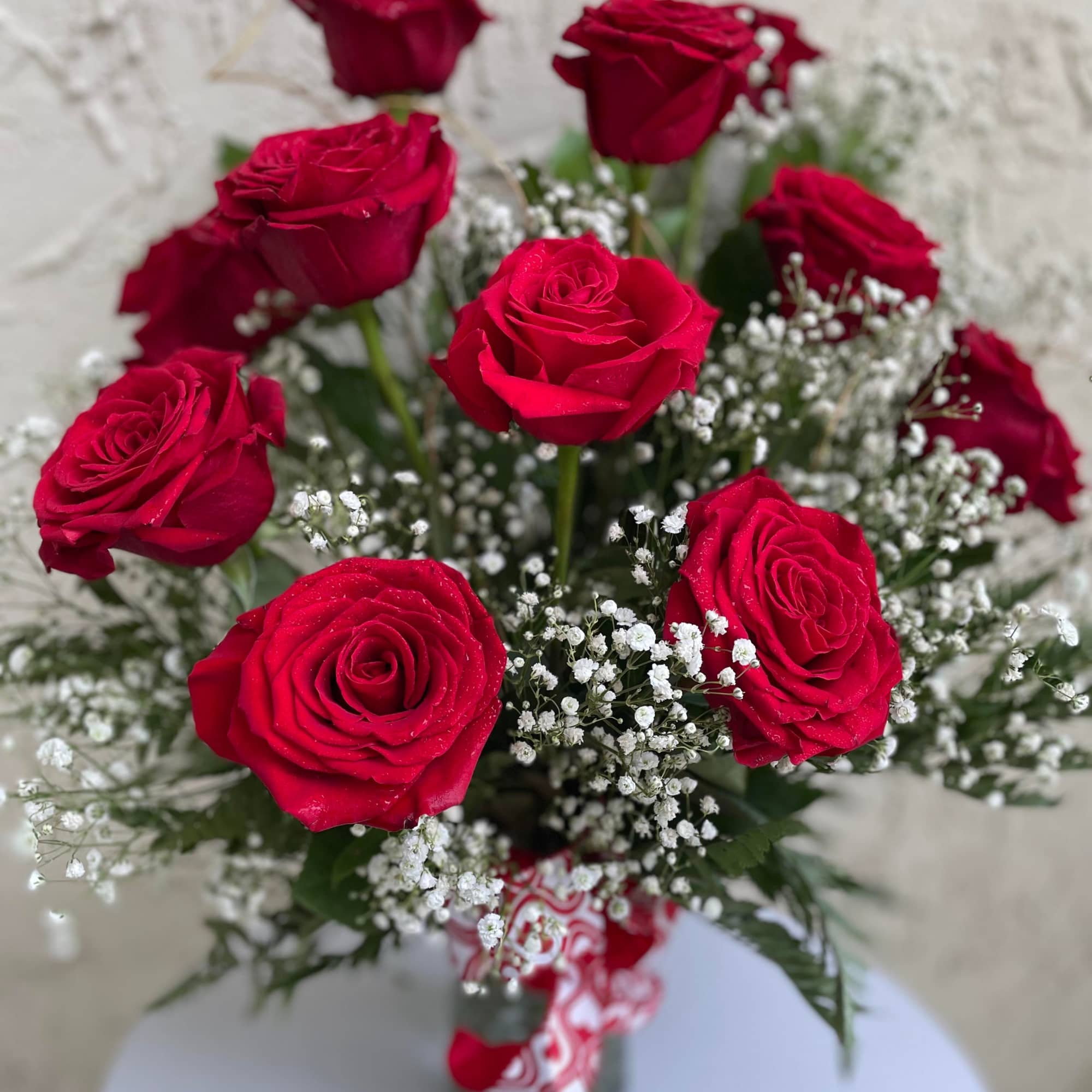 Bouquet of red roses with white baby's breath in a glass vase